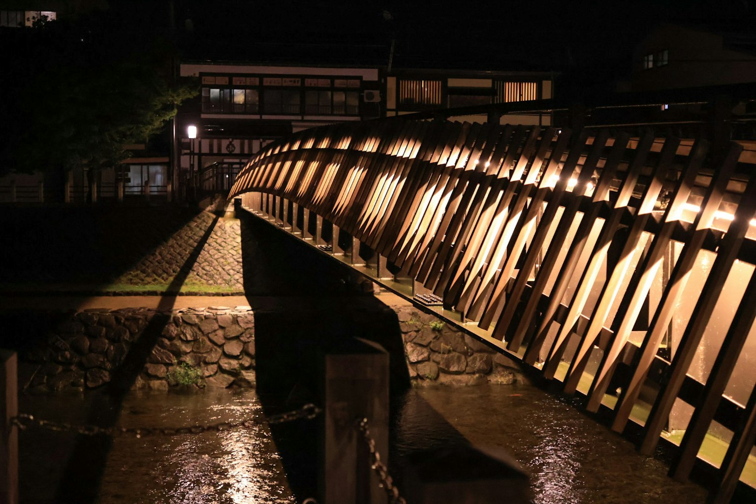 สะพานไม้ที่สวยงามถูกไฟส่องสว่างในตอนกลางคืน