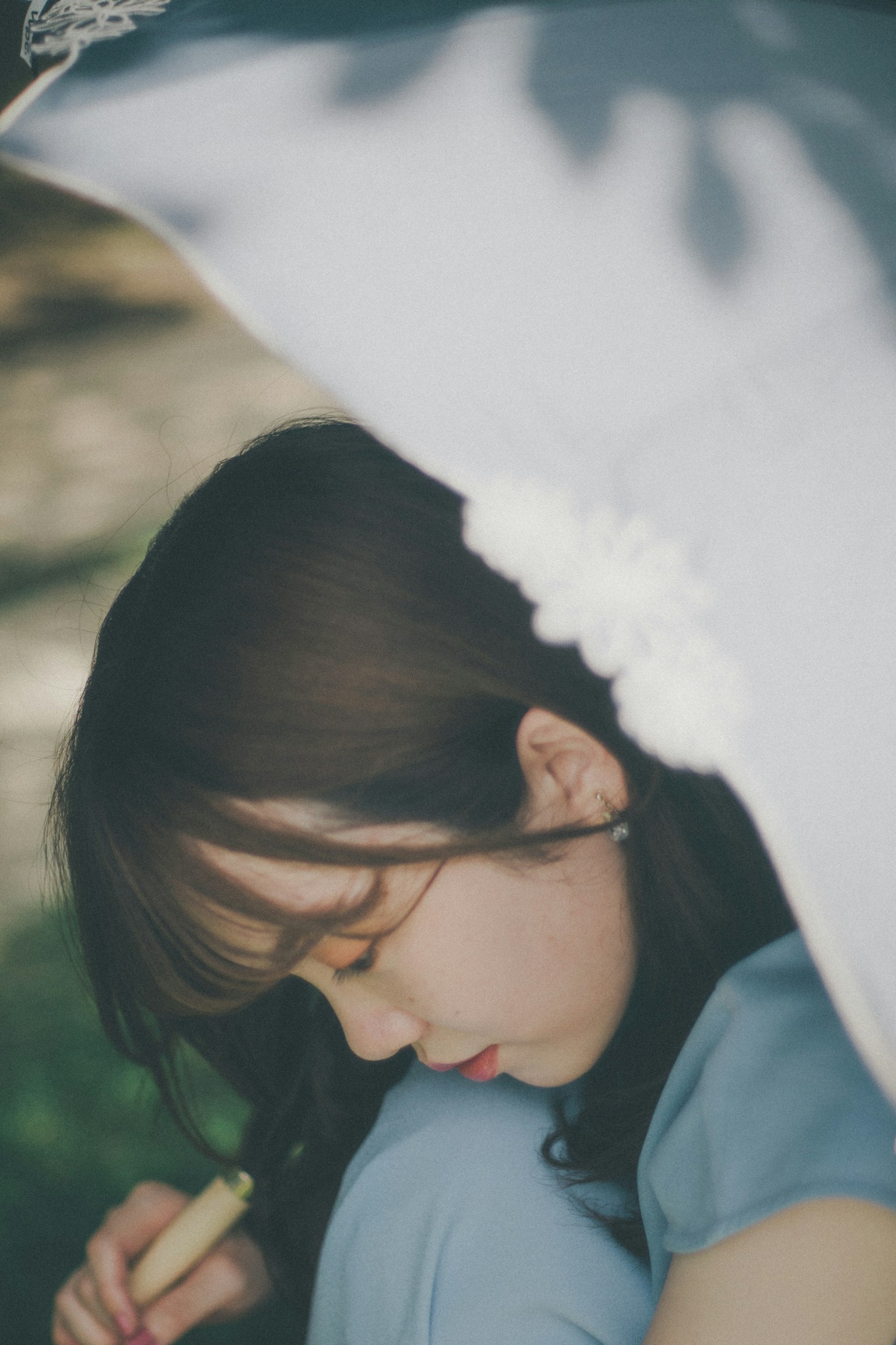一位女性静静地坐在阳伞下