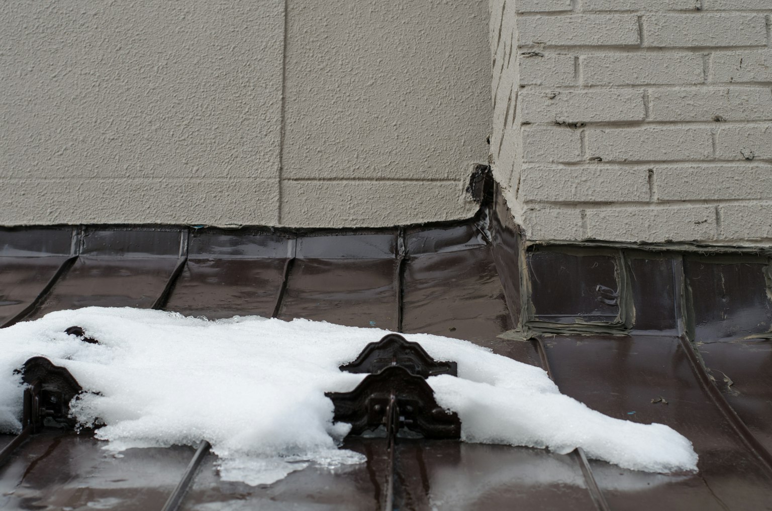 金属屋顶上的雪积累与相邻墙壁