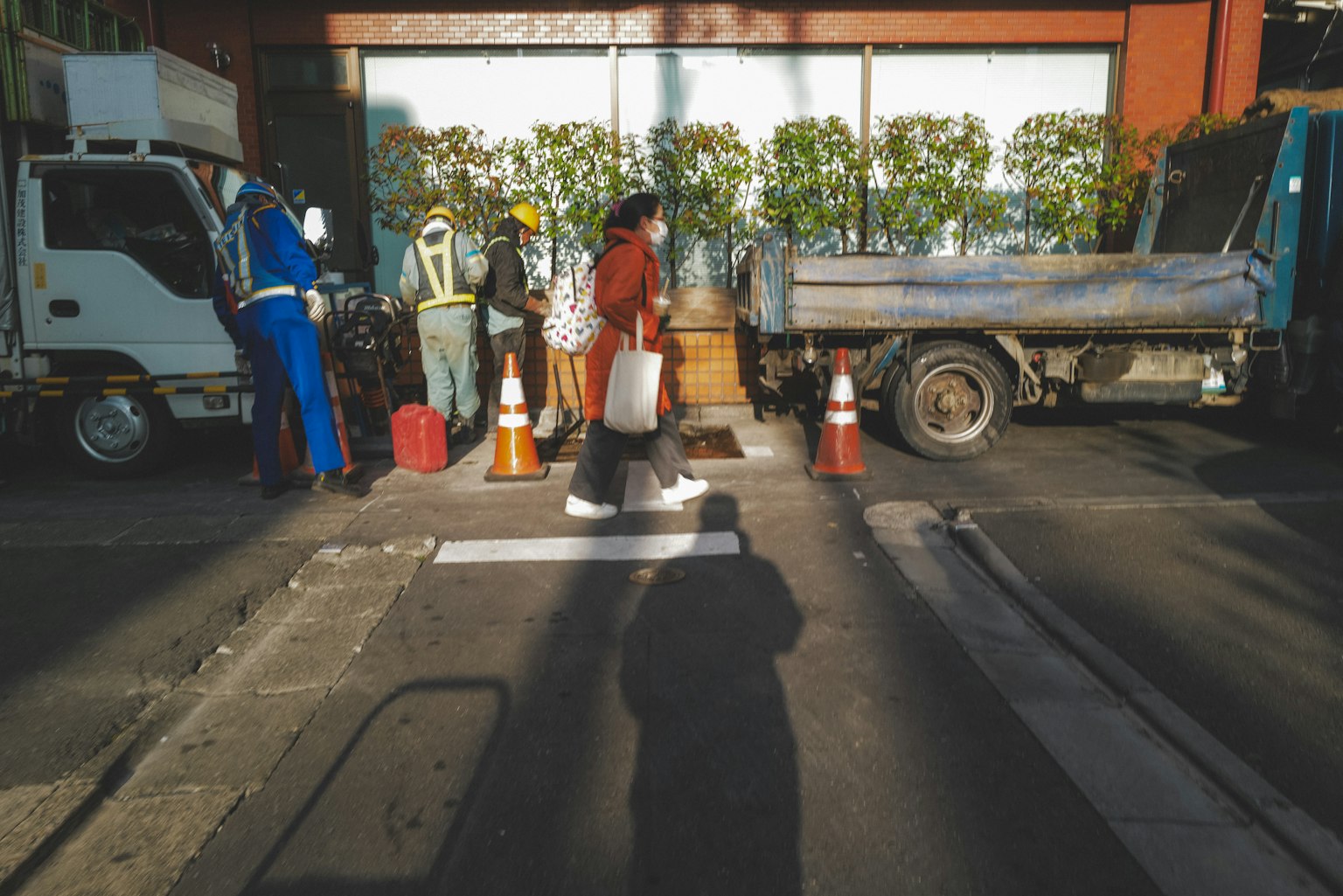 Une scène avec des piétons traversant la rue et des véhicules de travail