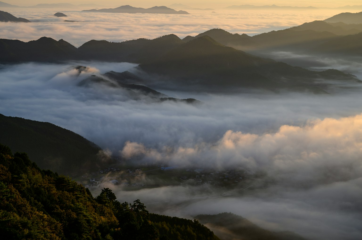 被雾气覆盖的山谷美丽景观，背景有山脉