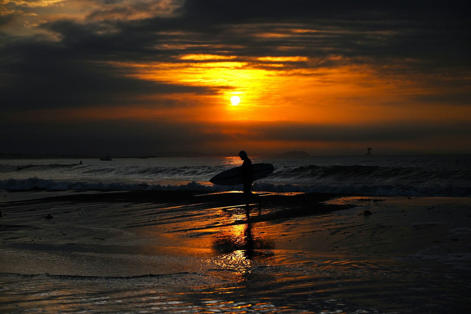 Silhouette of a surfer against a sunset at the beach