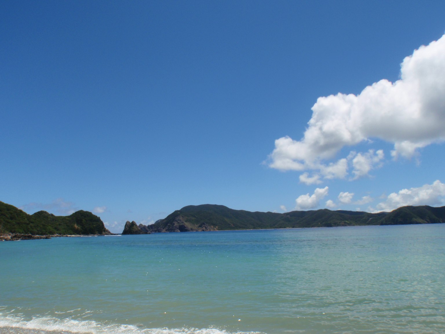 美丽的海滩景色，蓝色海洋和白色云朵