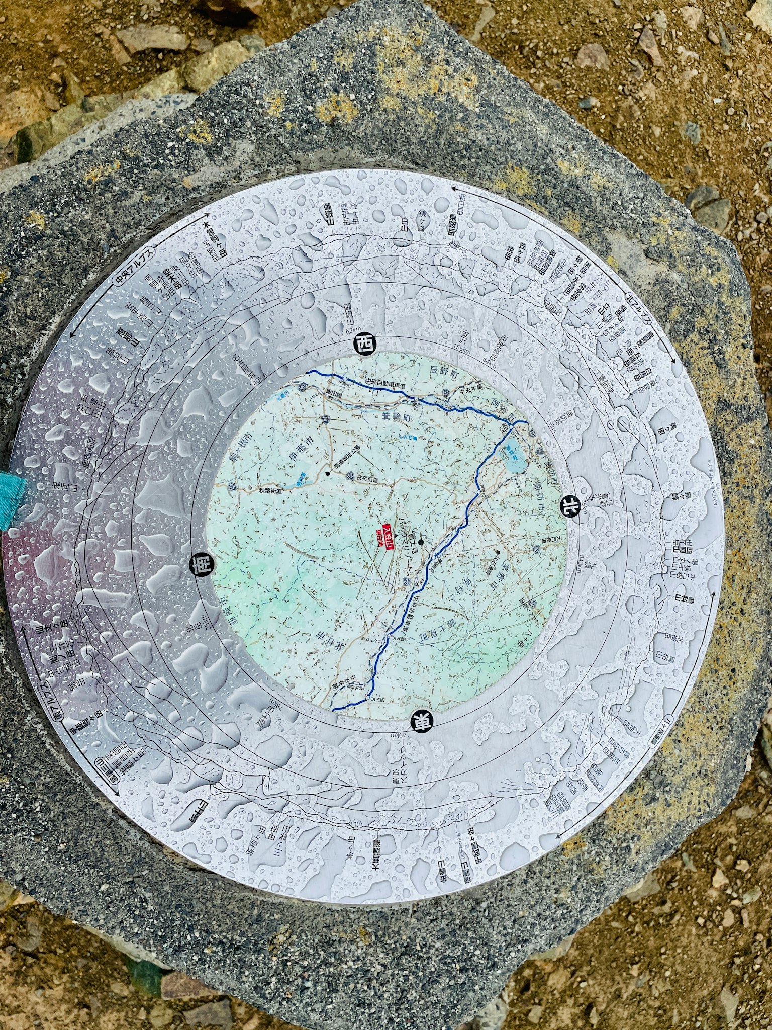 一个安装在地上的金属地图板被雨水覆盖