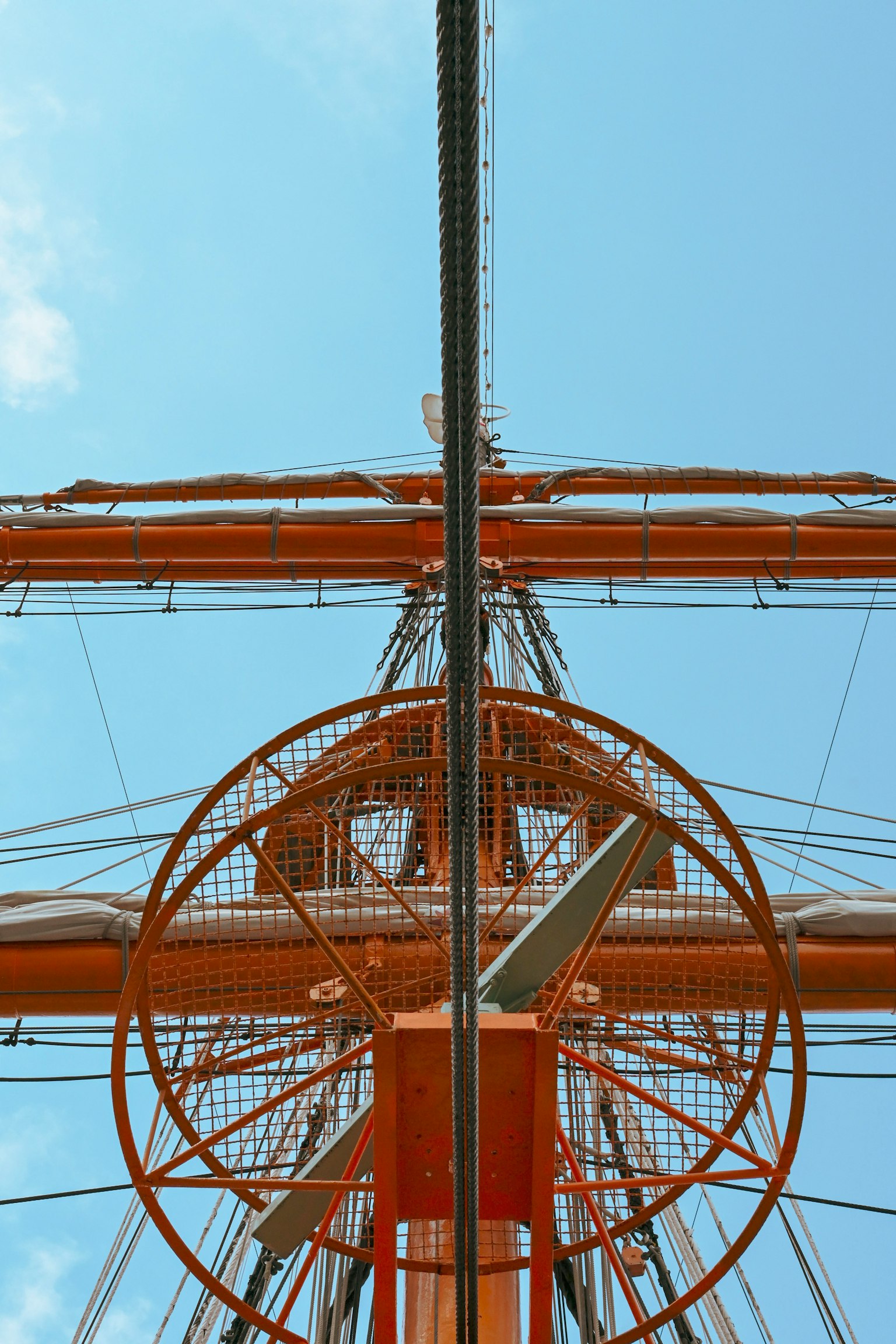 Blick auf den Mast und die Segelstruktur eines Schiffes vor blauem Himmel
