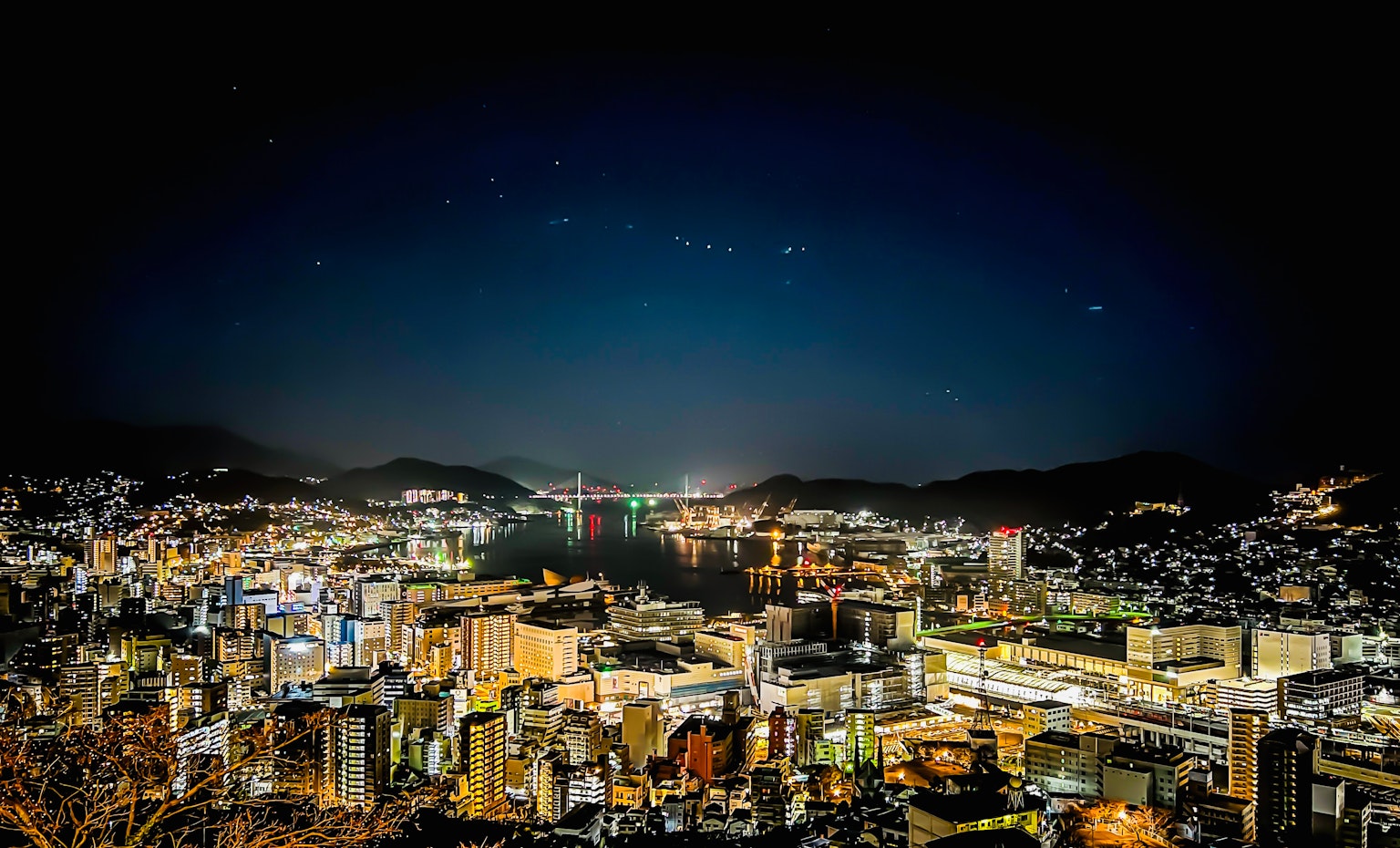 Panoramablick auf eine nächtliche Stadtlandschaft mit Sternen am Himmel