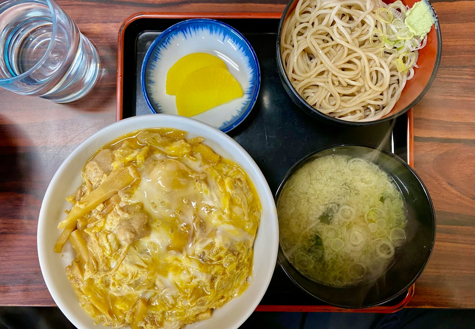 Warm chicken and egg rice bowl served with soba noodles miso soup and pickles