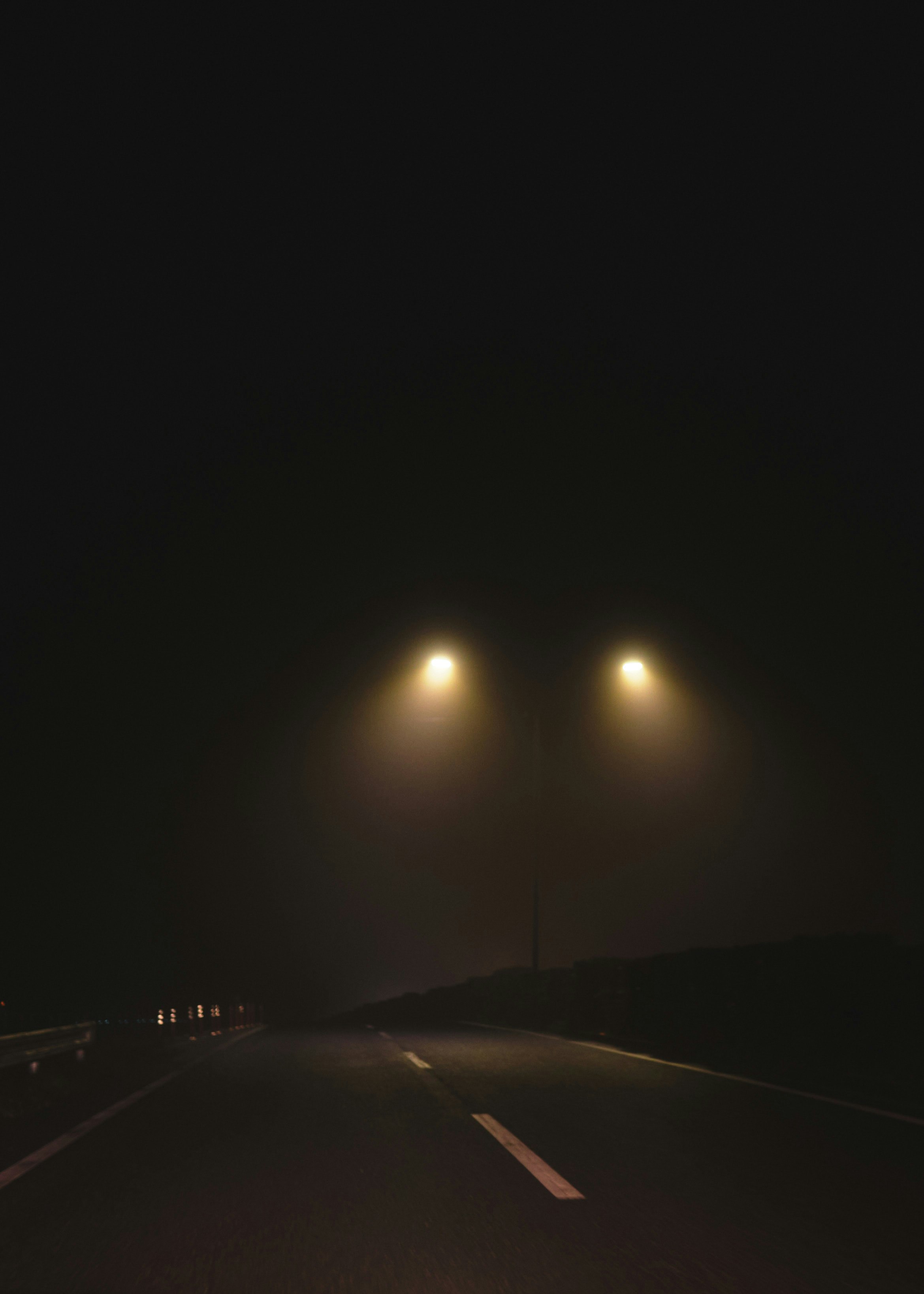霧の夜の高速道路を走る車線の光