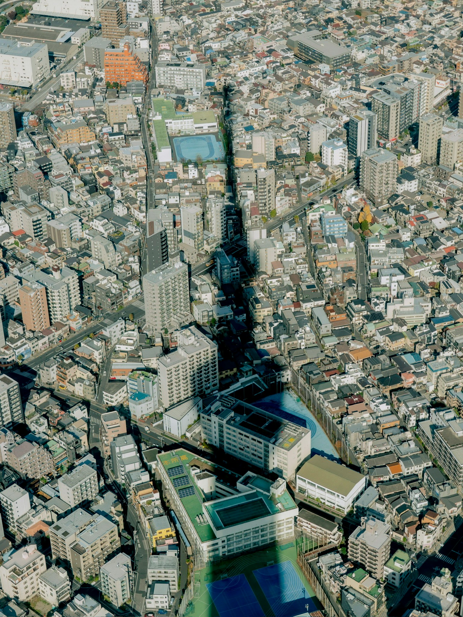 東京の街並みの上空からの視点で東京タワーの影が見える