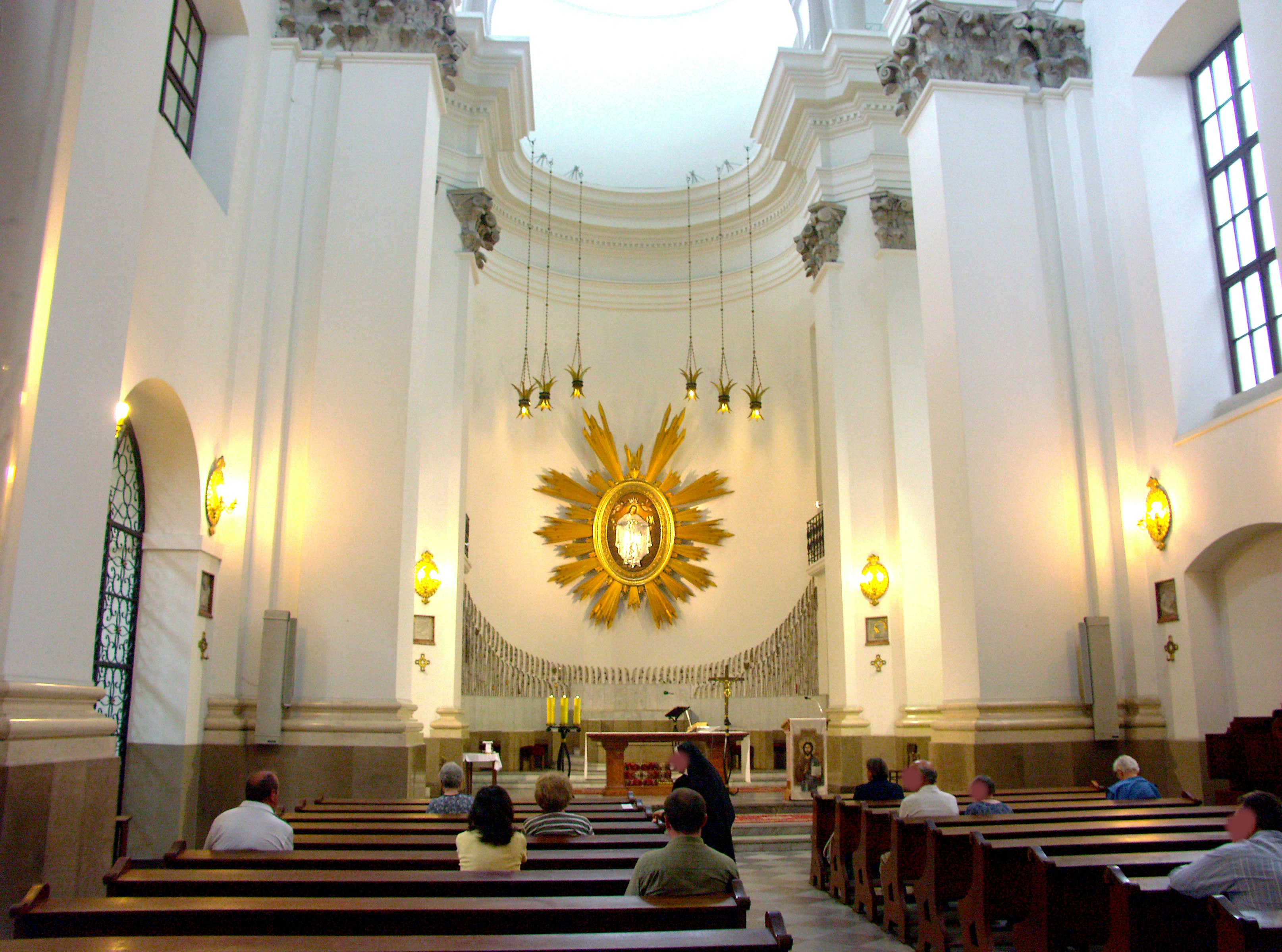 interior de una iglesia blanca con altar y vitrales