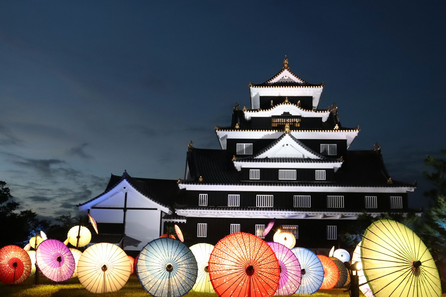 夜晚传统日本城堡前的彩色伞