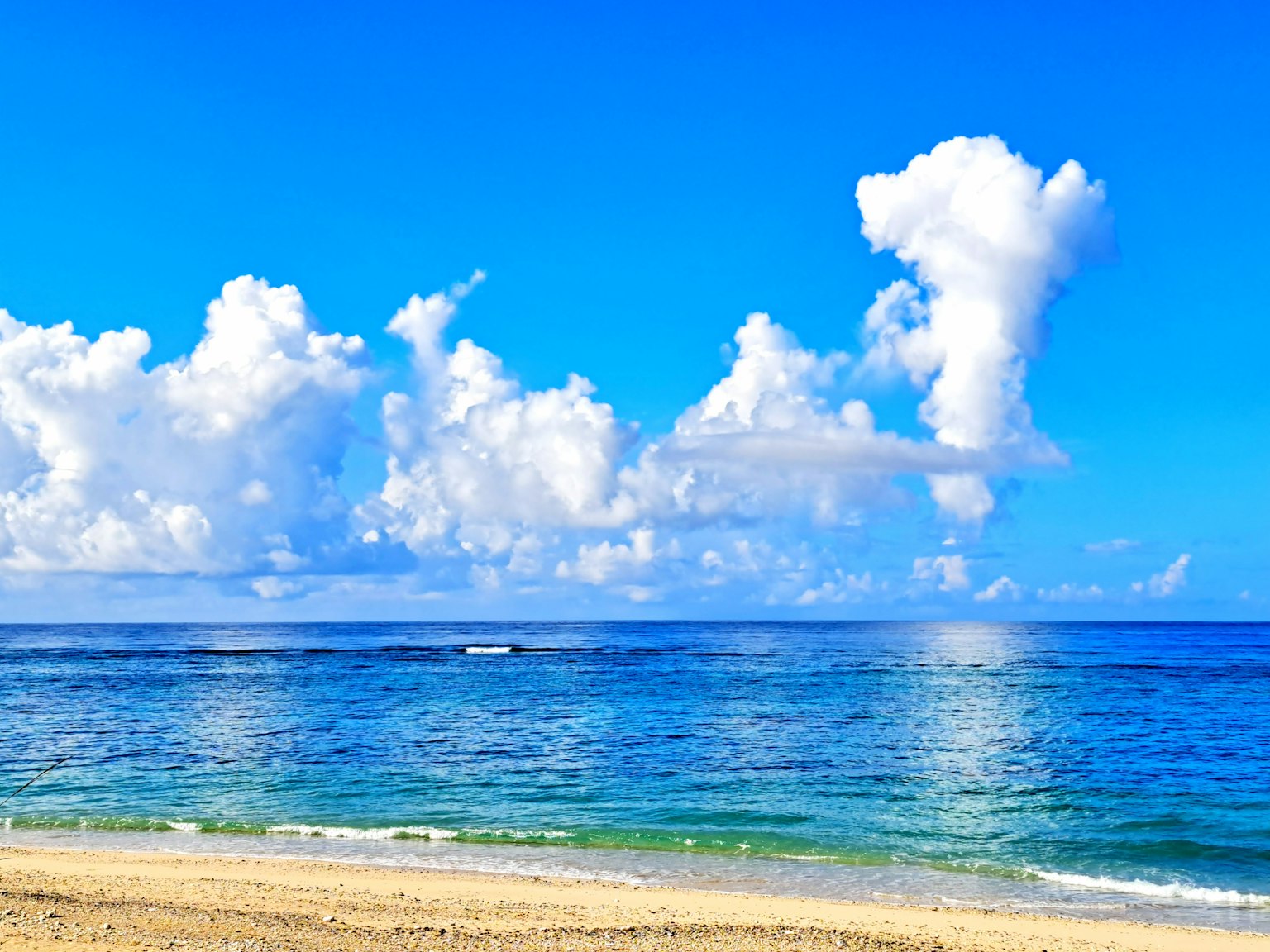 Pemandangan pantai yang indah dengan laut biru dan awan putih