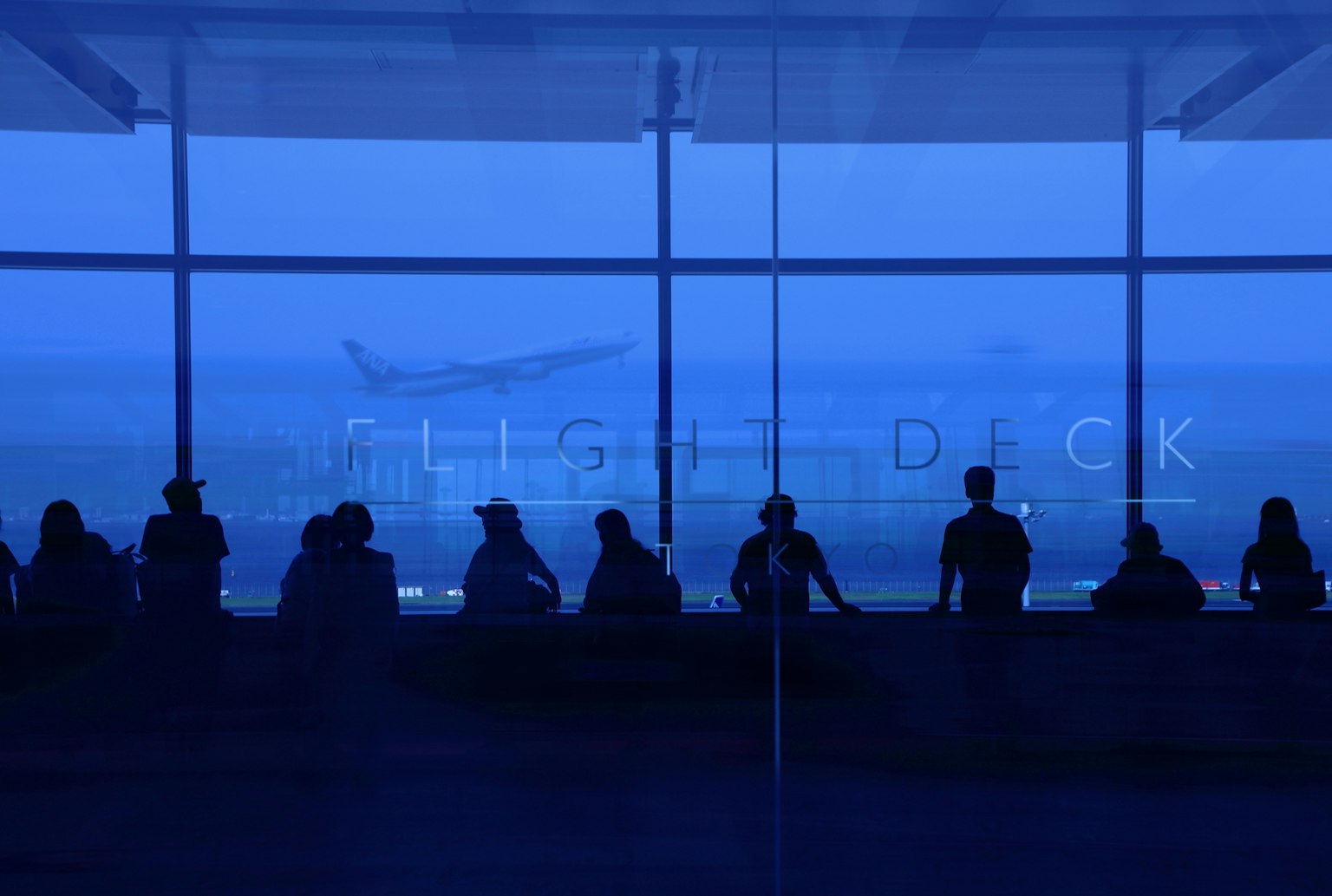 Silhouettes de personnes au poste de pilotage d'un aéroport sur fond bleu