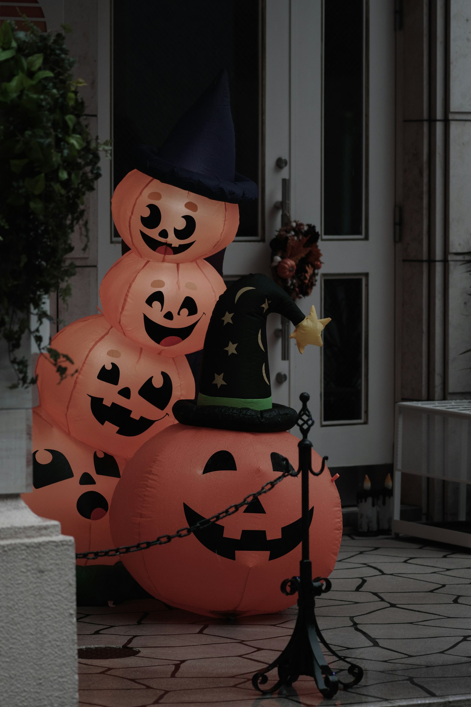 Decoraciones de Halloween con calabazas apiladas y un sombrero de bruja