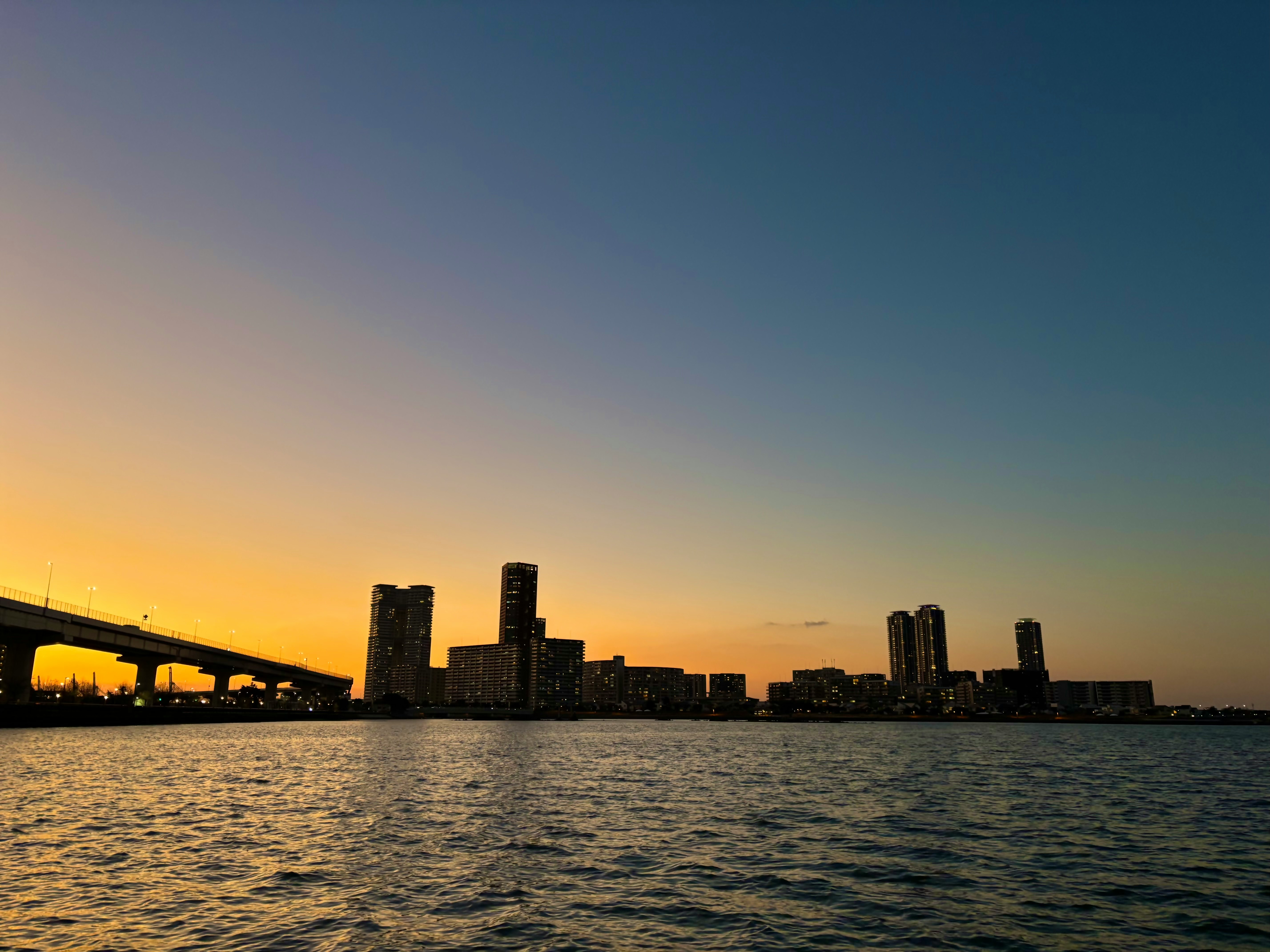 tramonto sul mare con skyline di grattacieli