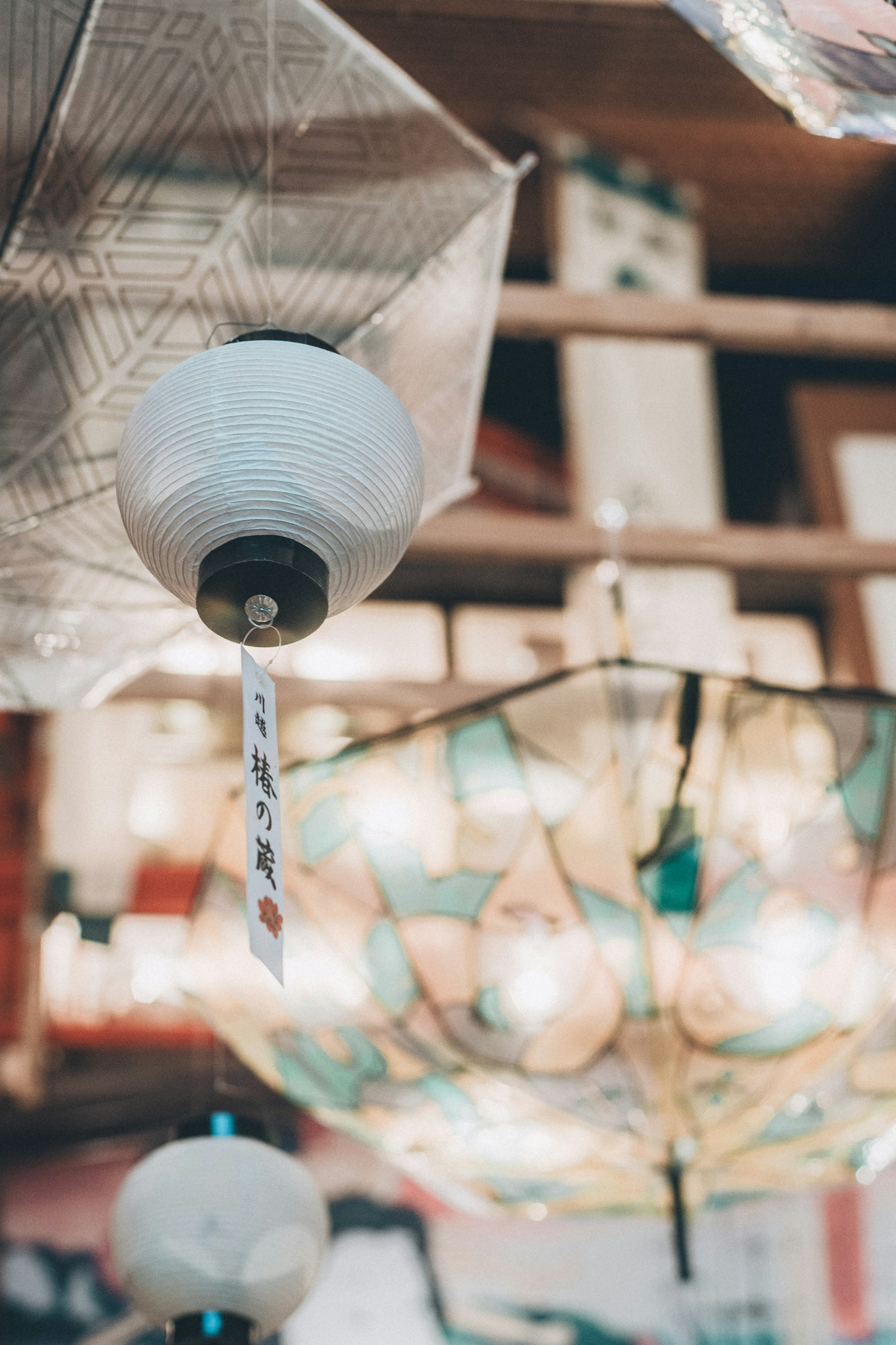 Une scène avec des lanternes blanches et des parapluies colorés suspendus
