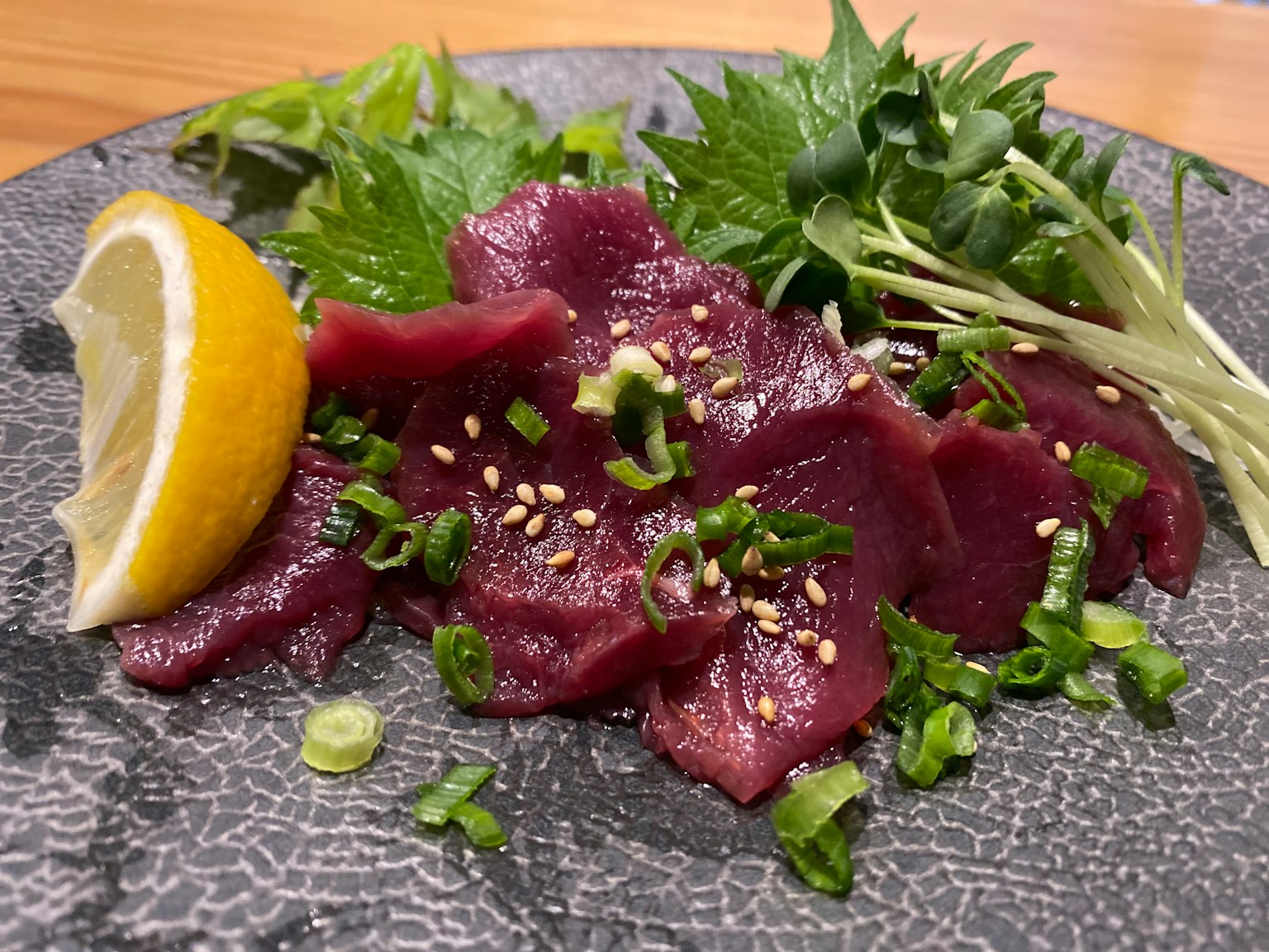 Sashimi ngựa tươi được phục vụ với chanh và rau trang trí