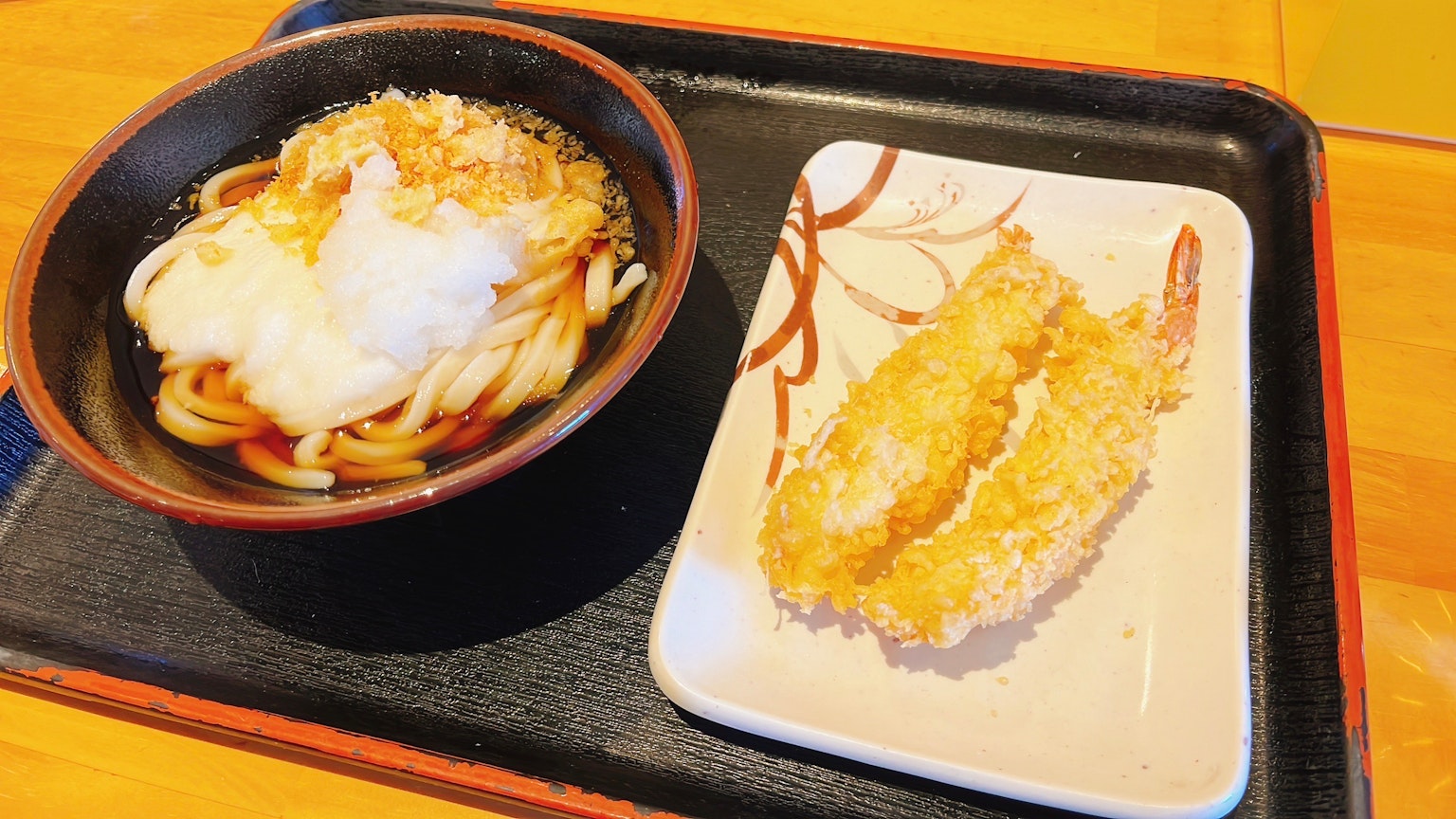Udon con gamberi tempura serviti su un vassoio
