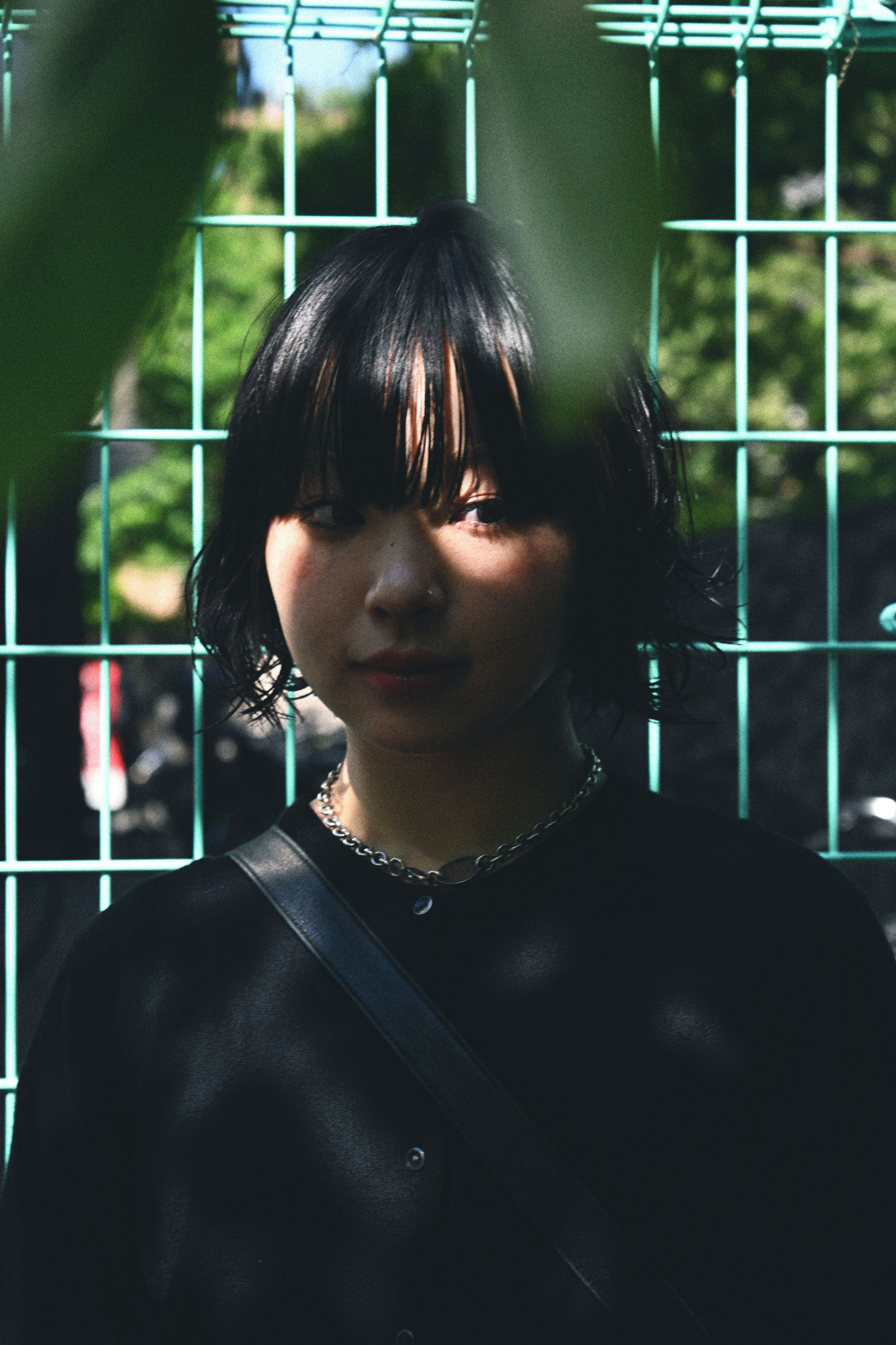 金属フレームの前で黒い服の女性のポートレート