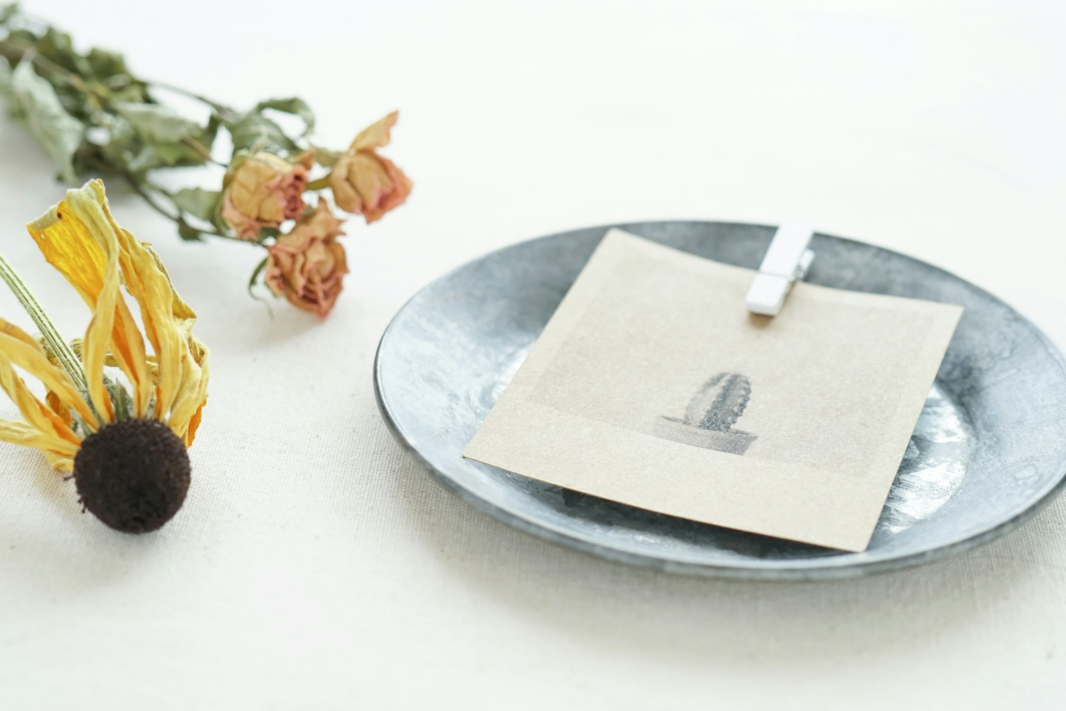 Envelope placed on a plate with dried flower arrangement