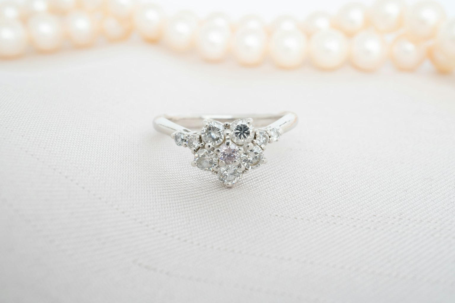 Una bellissima anello di diamanti posato su una collana di perle