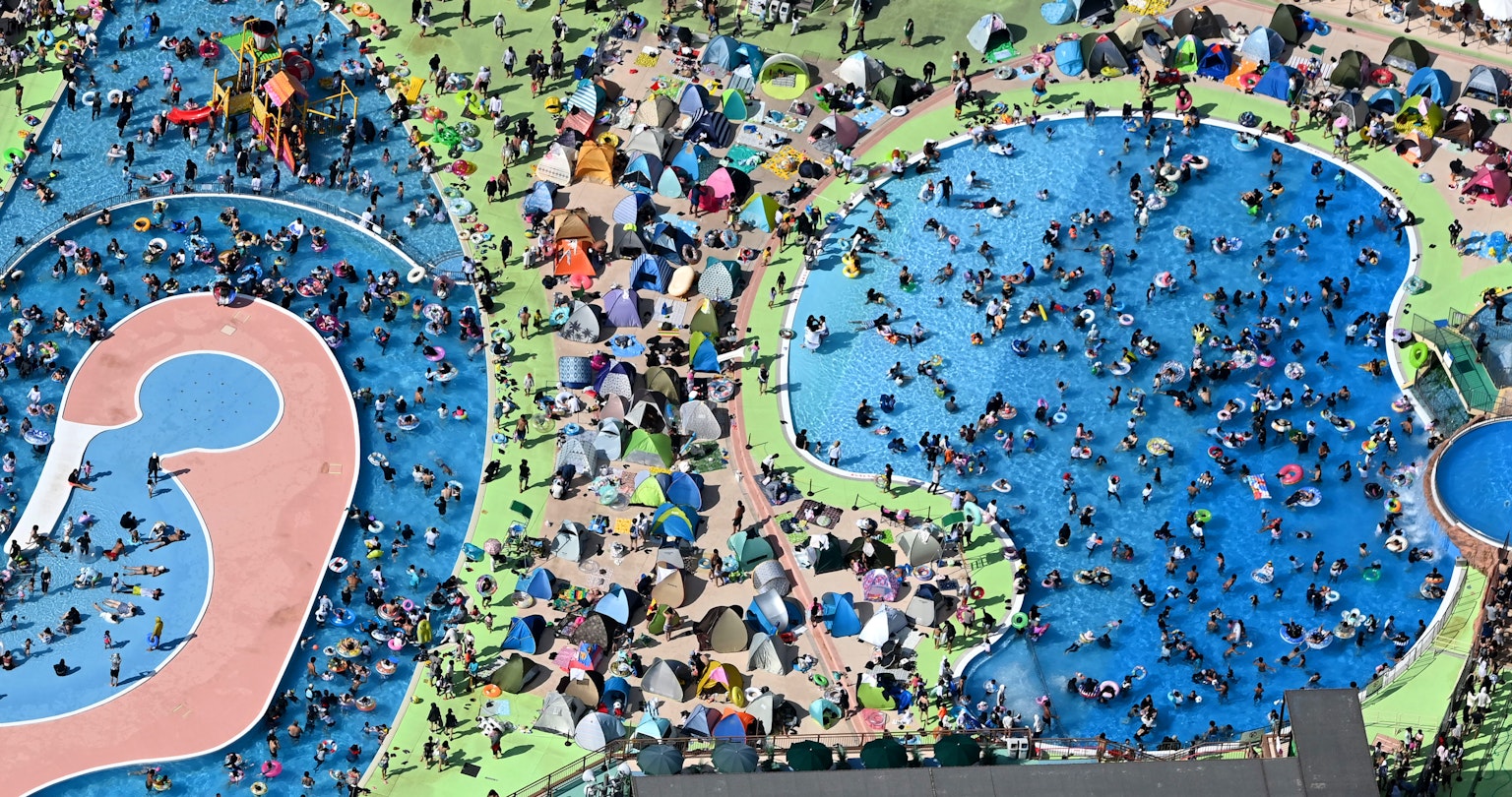 Crowded colorful pool area with people enjoying water activities