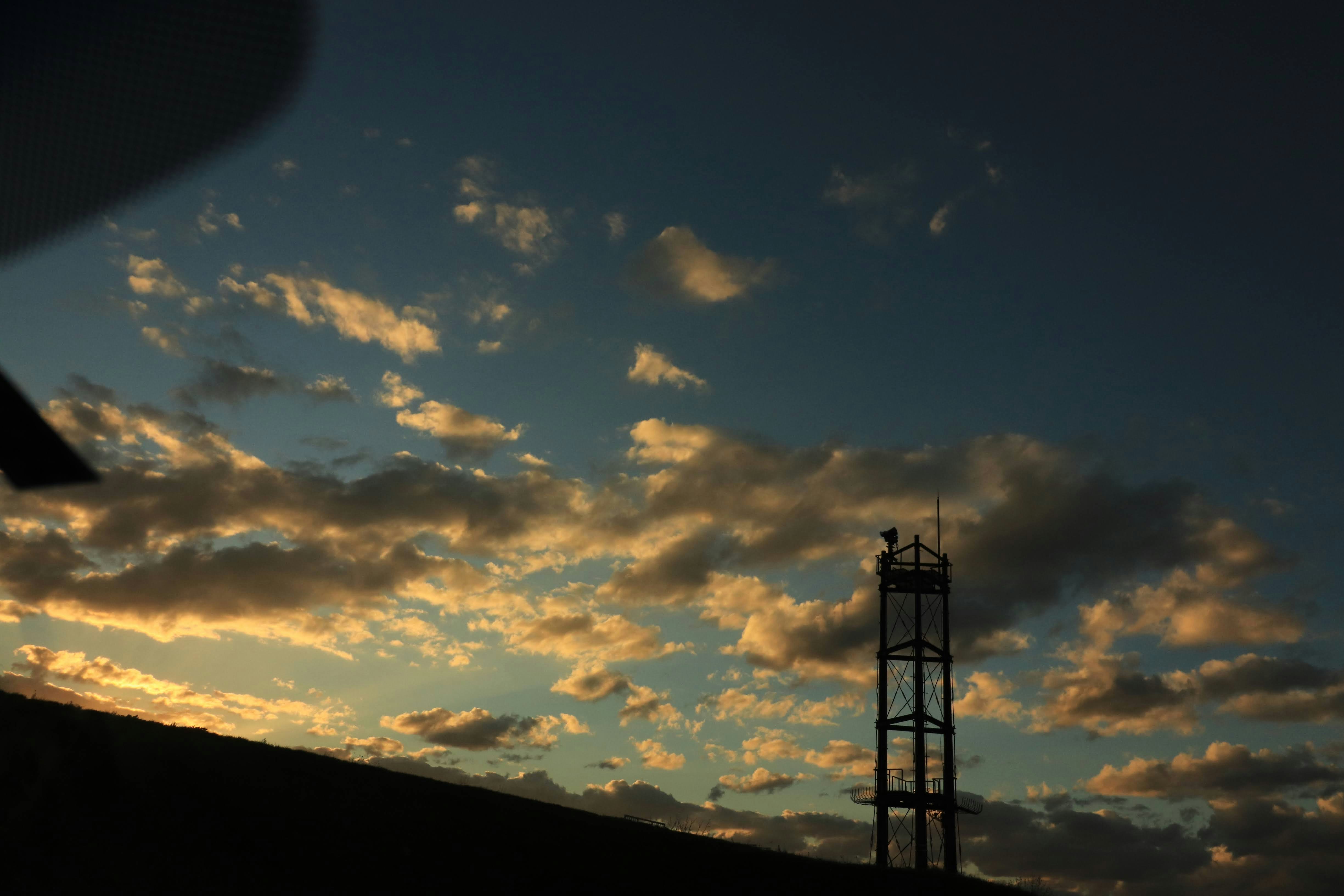 silueta de una chimenea contra un cielo de atardecer con nubes
