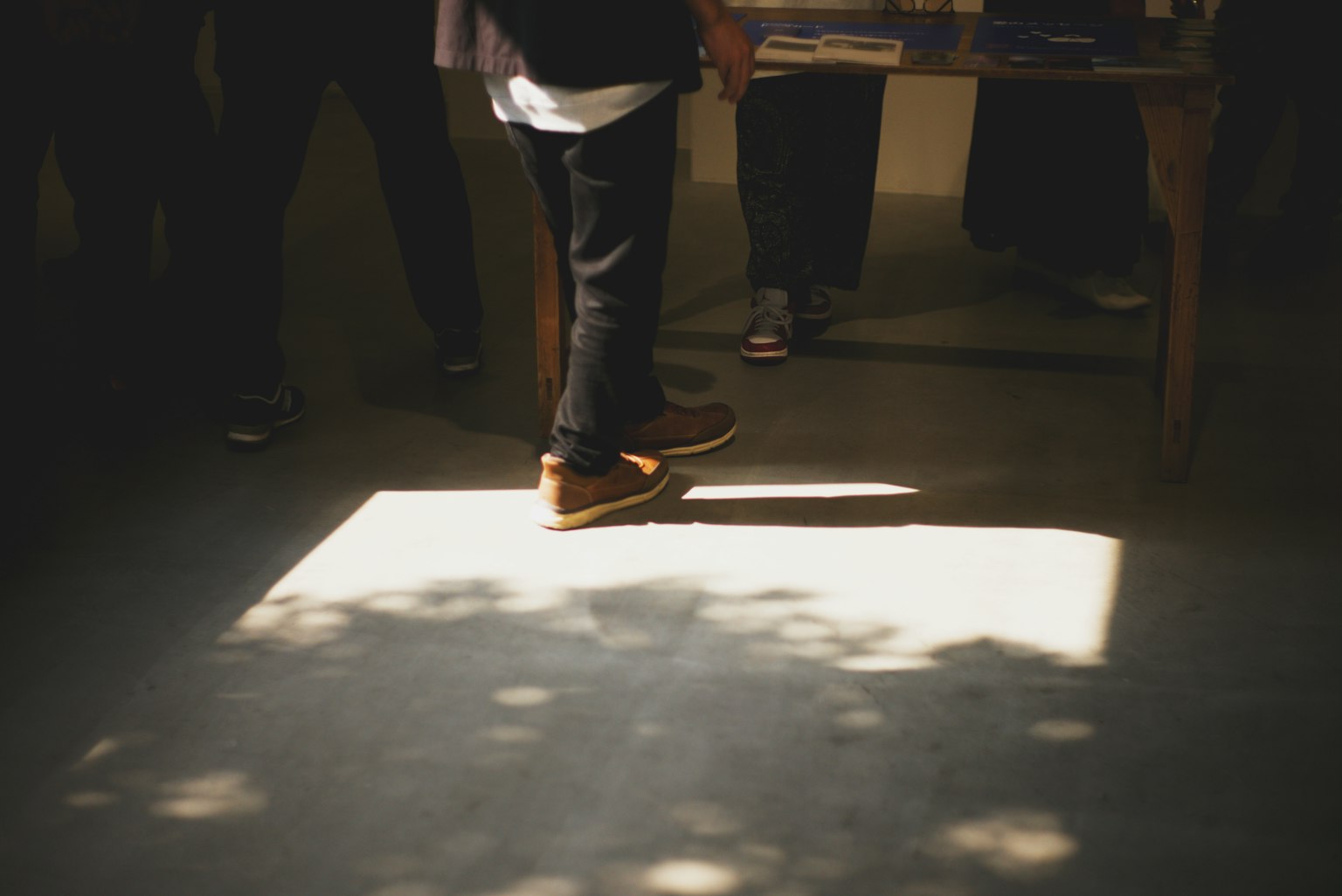 테이블 앞에 서 있는 사람의 발과 그림자와 햇빛