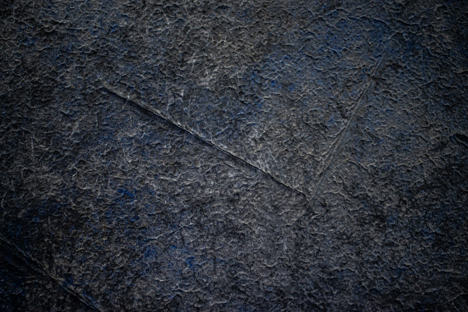 Surface texturée en tons sombres avec des lignes subtiles