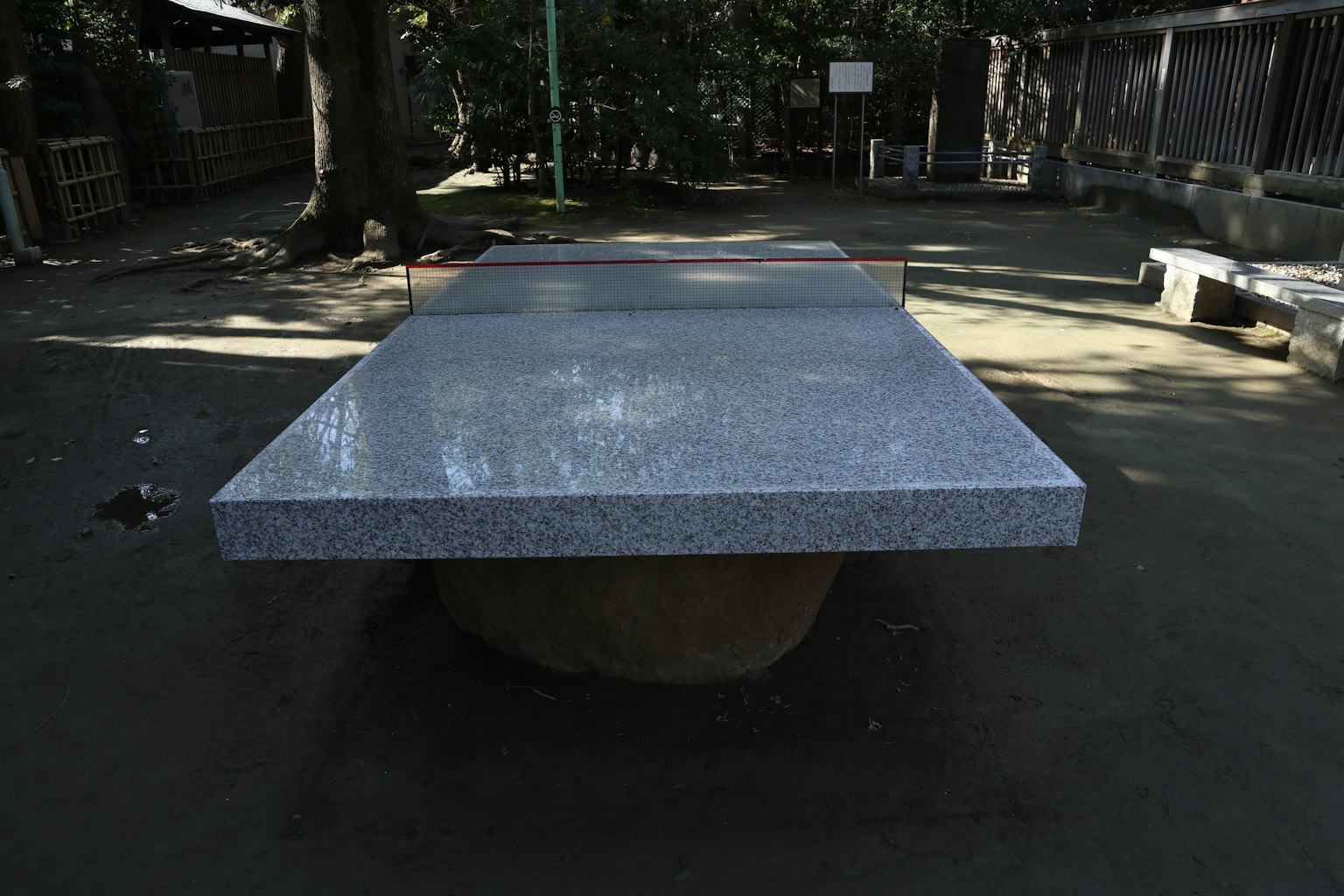 Tavolo in pietra in un parco con panchine circostanti