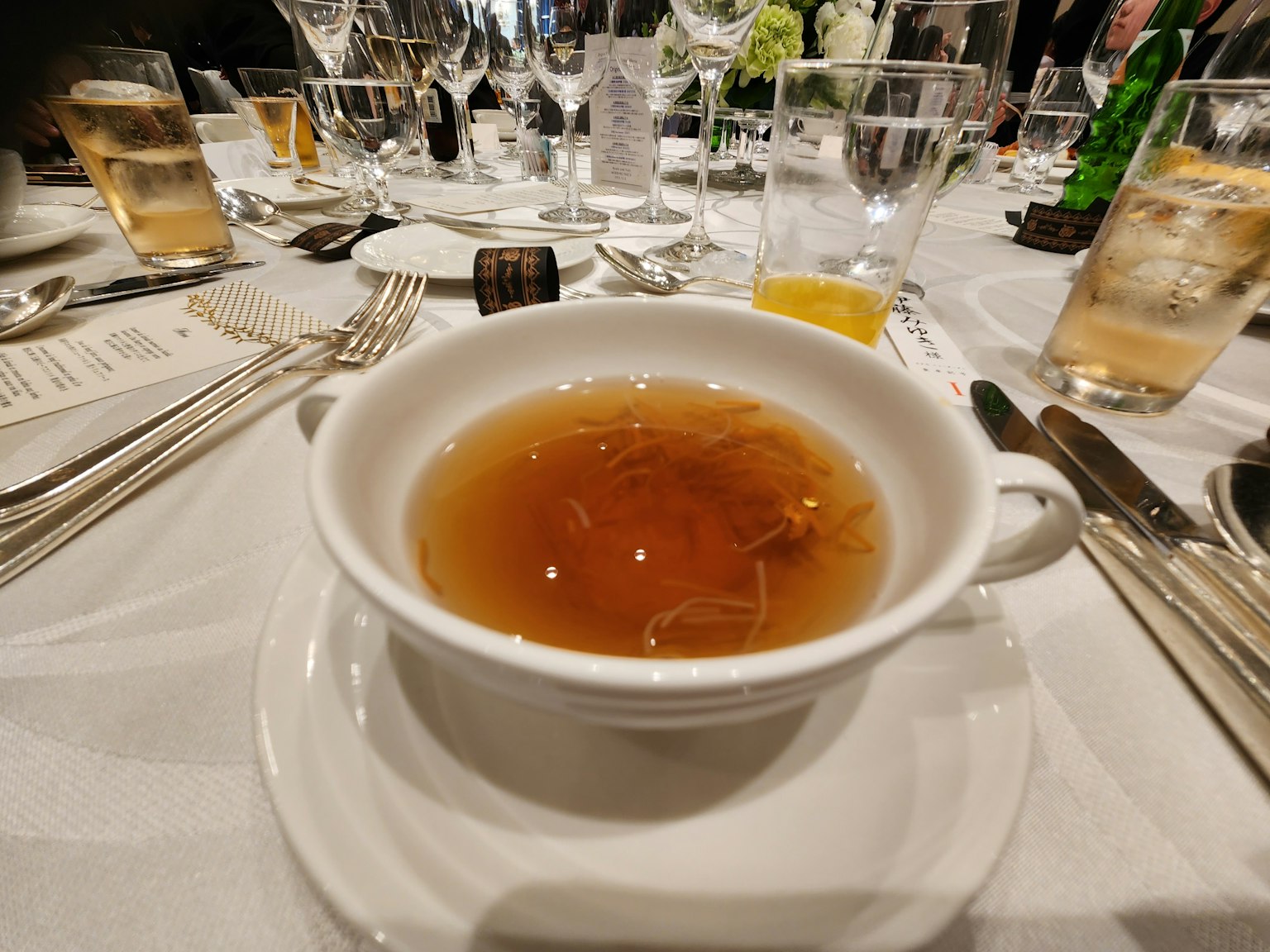 Une tasse de soupe chaude servie sur une assiette blanche à une table à manger