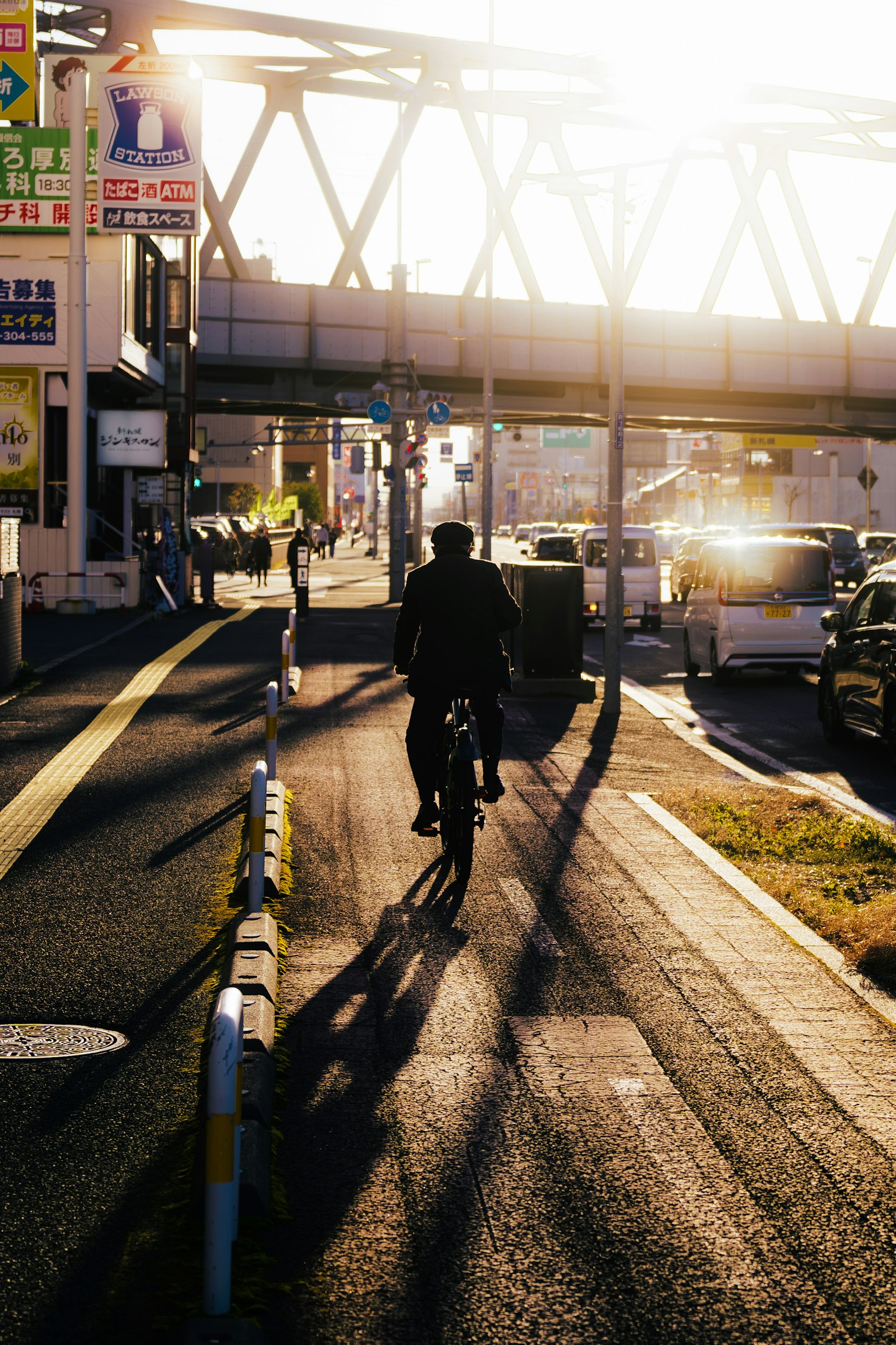 Silhouette of a person cycling in the sunset with urban scenery