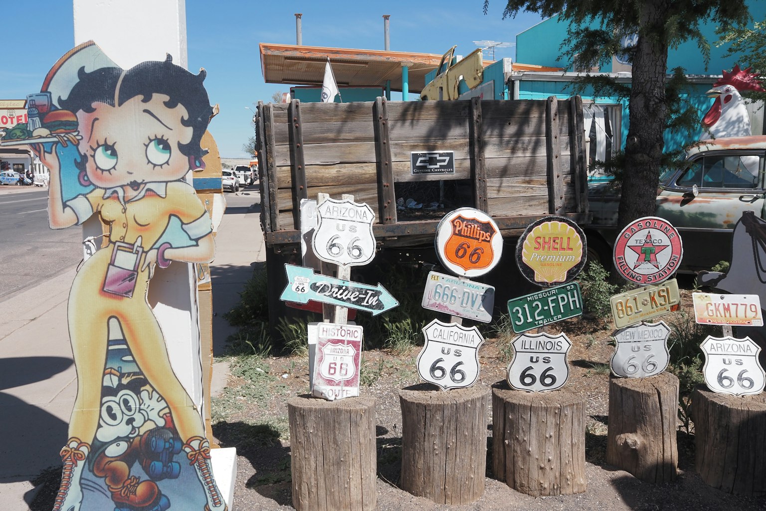 Biển hiệu với nhân vật Betty Boop và biển báo Route 66 trên thân gỗ