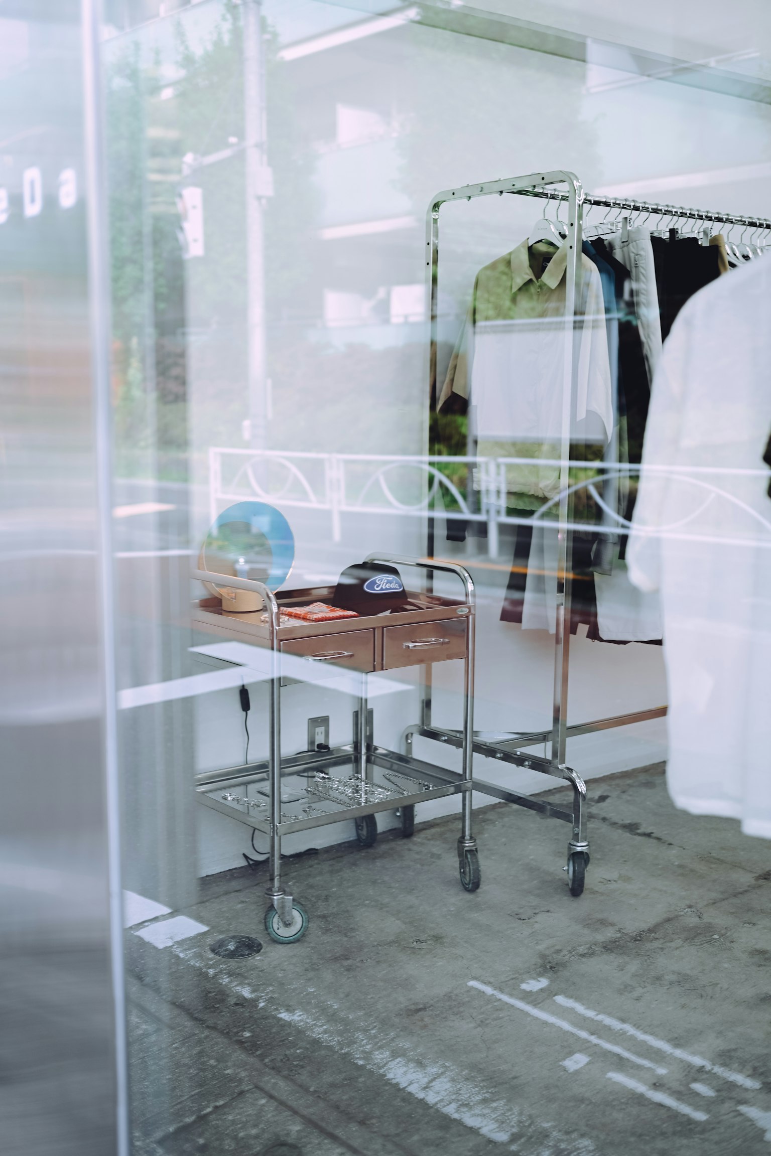 Ropa expuesta detrás de una ventana transparente con una mesa de madera