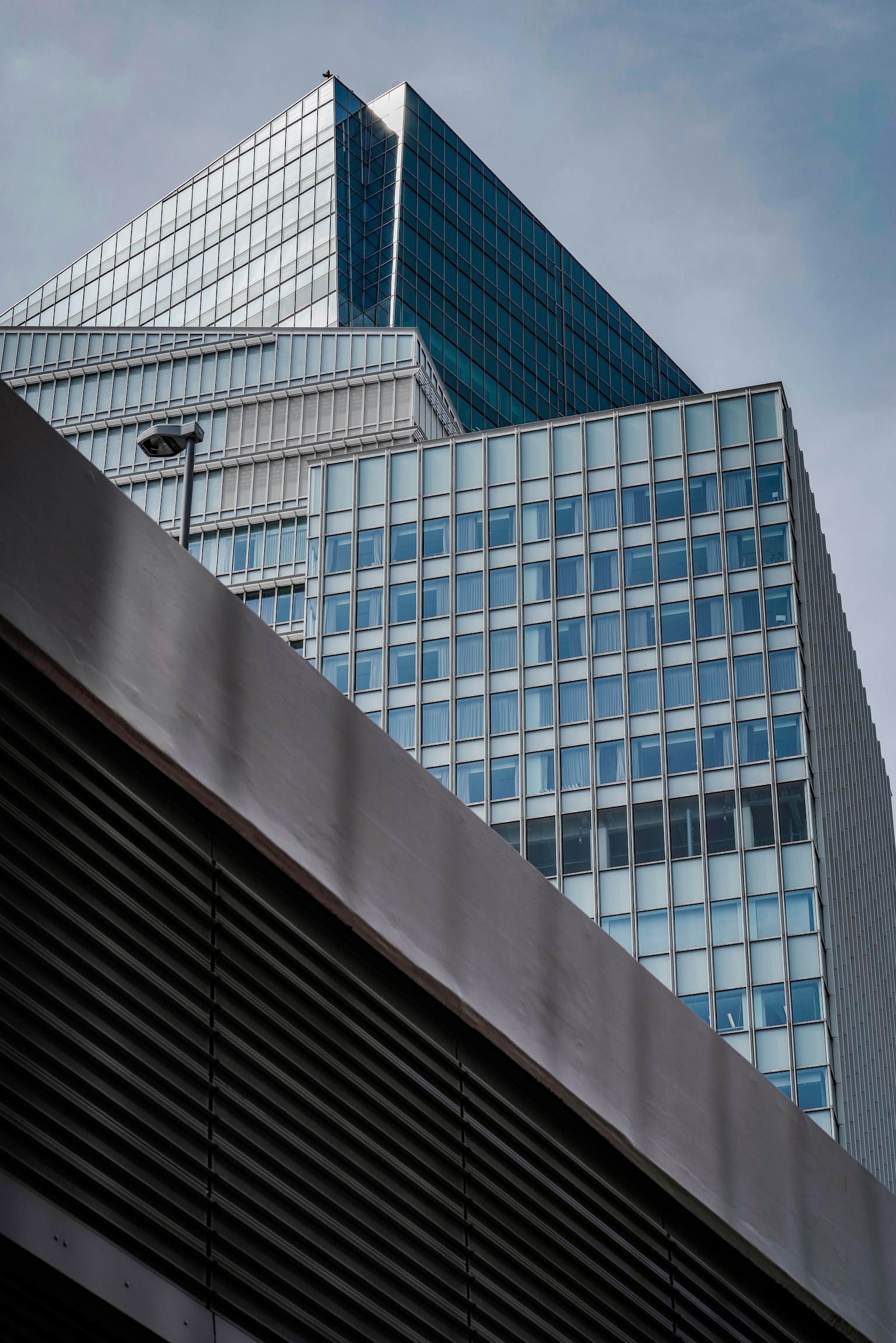 近代的なビルの上部が見える構図でガラスの反射が特徴的