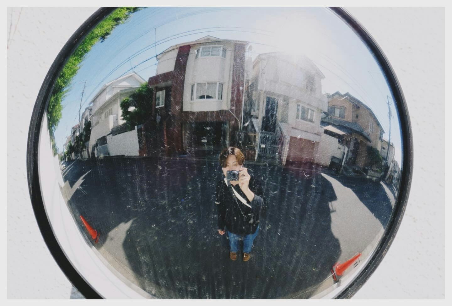 street scene with pedestrians reflected in a bicycle mirror