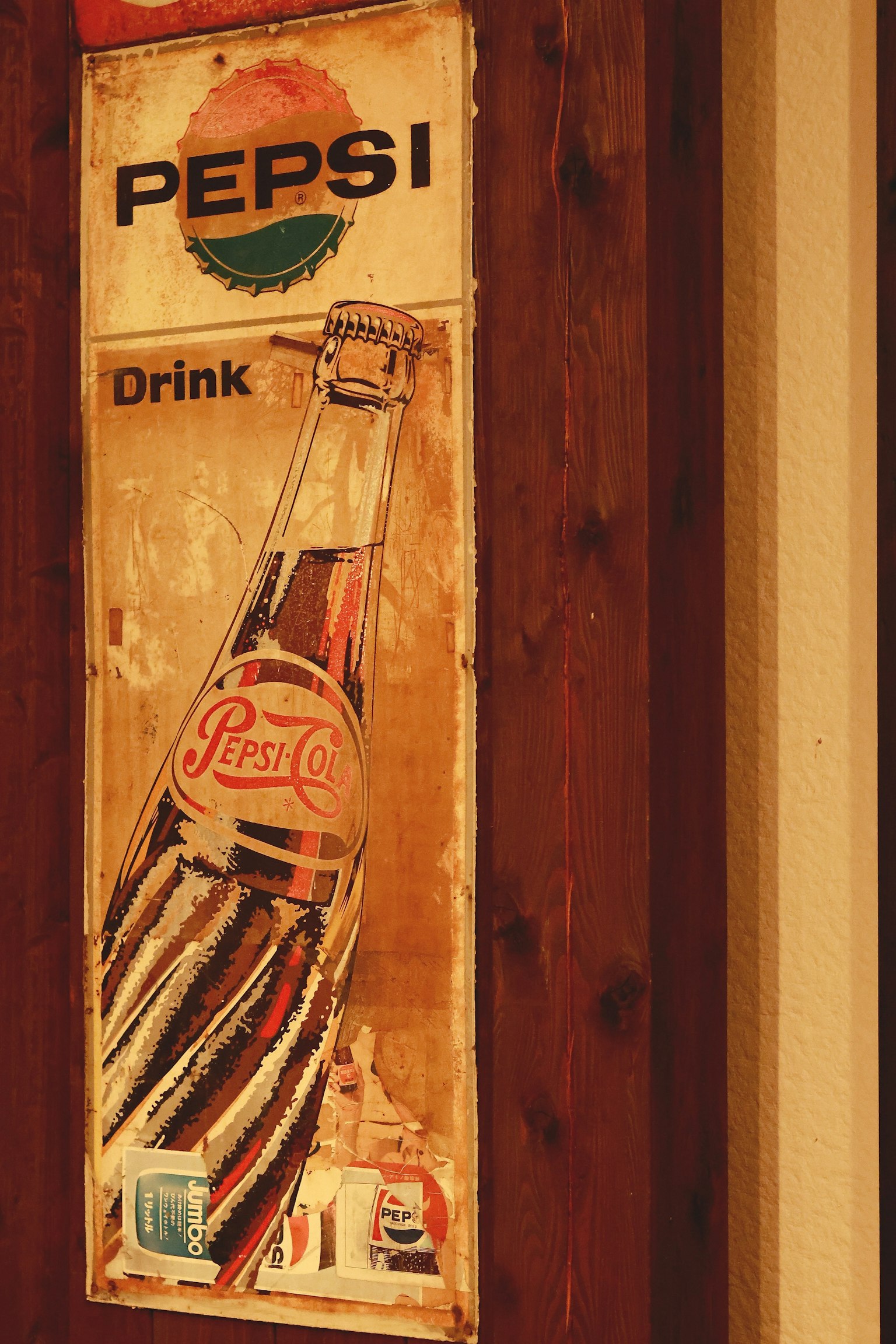 Vintage Pepsi advertisement sign mounted on a wooden wall