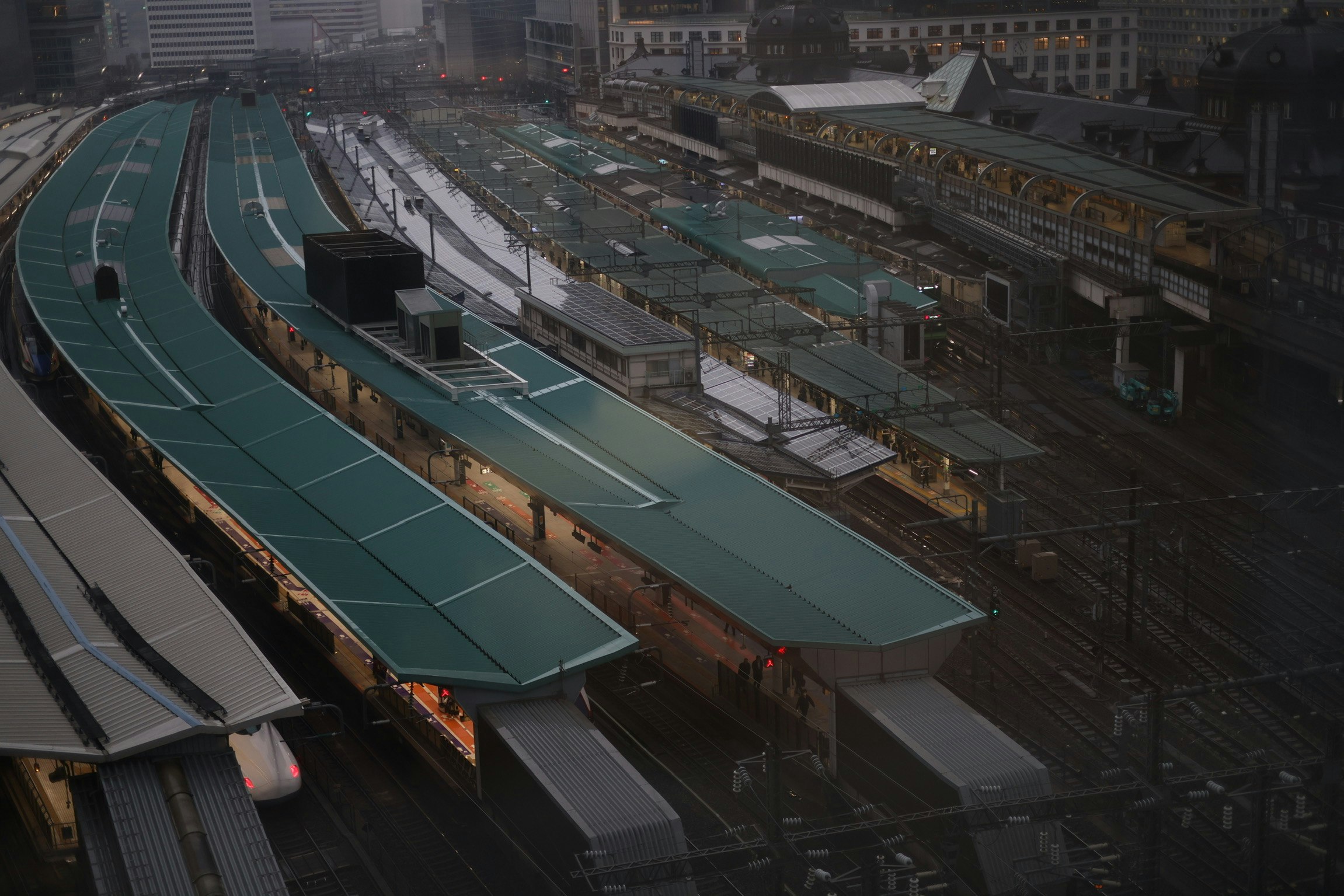 ชานชาลาและรางรถไฟของสถานีโตเกียวในช่วงเย็นที่ฝนตก