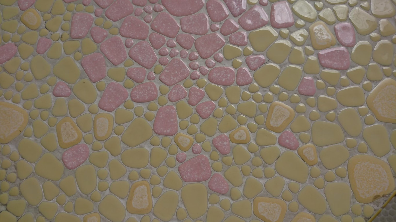 Textured wall with light pink and yellow stone pattern