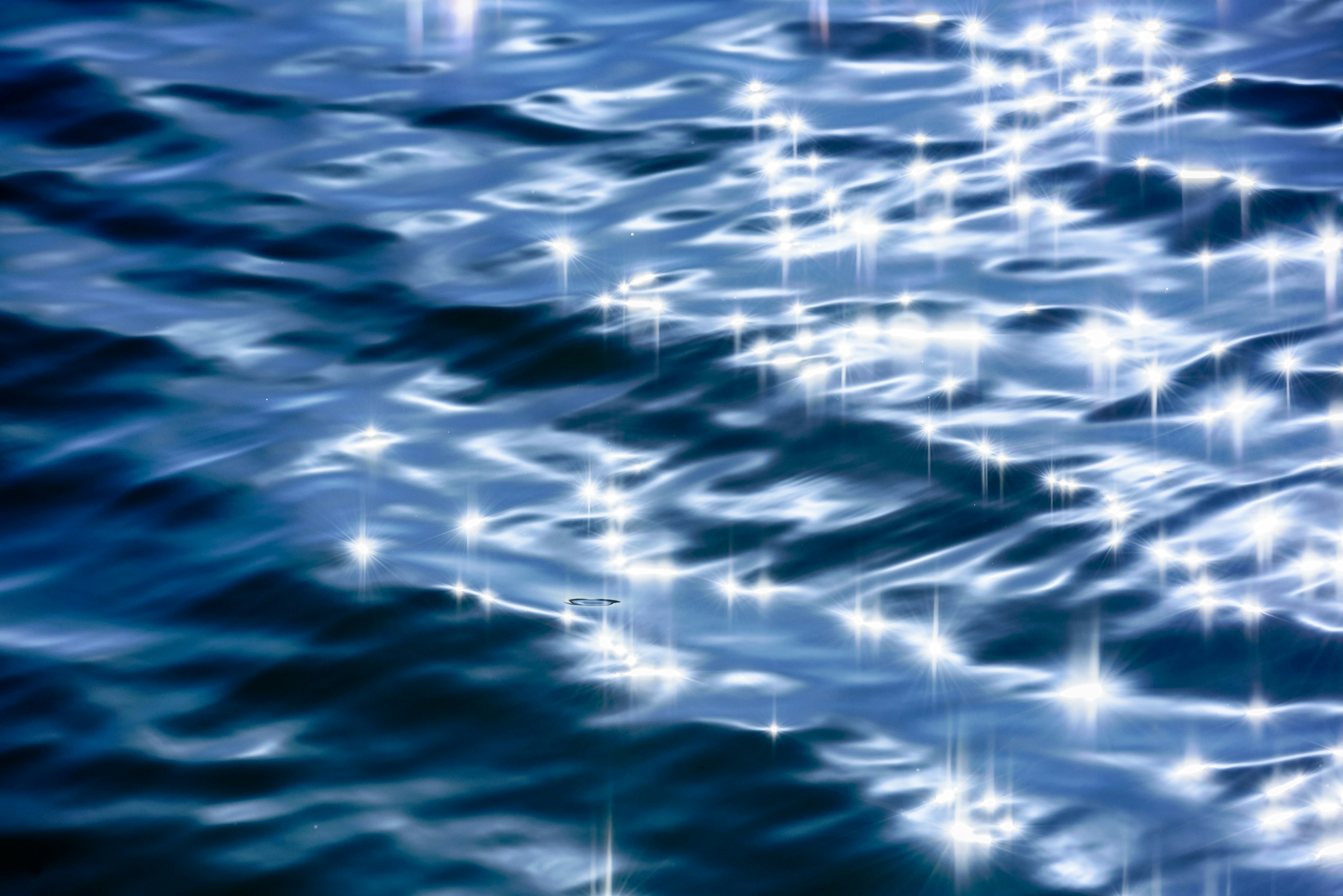 sparkling light on a blue ocean wave surface