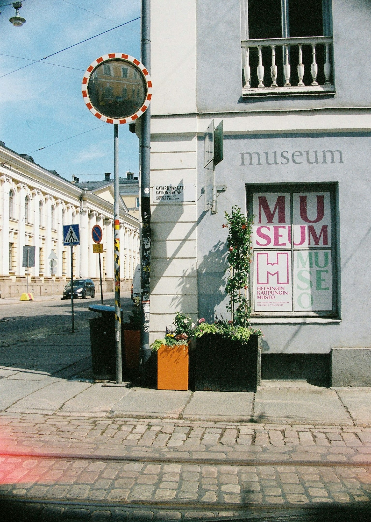 Exterior of a museum featuring colorful lettering on the window and a street view