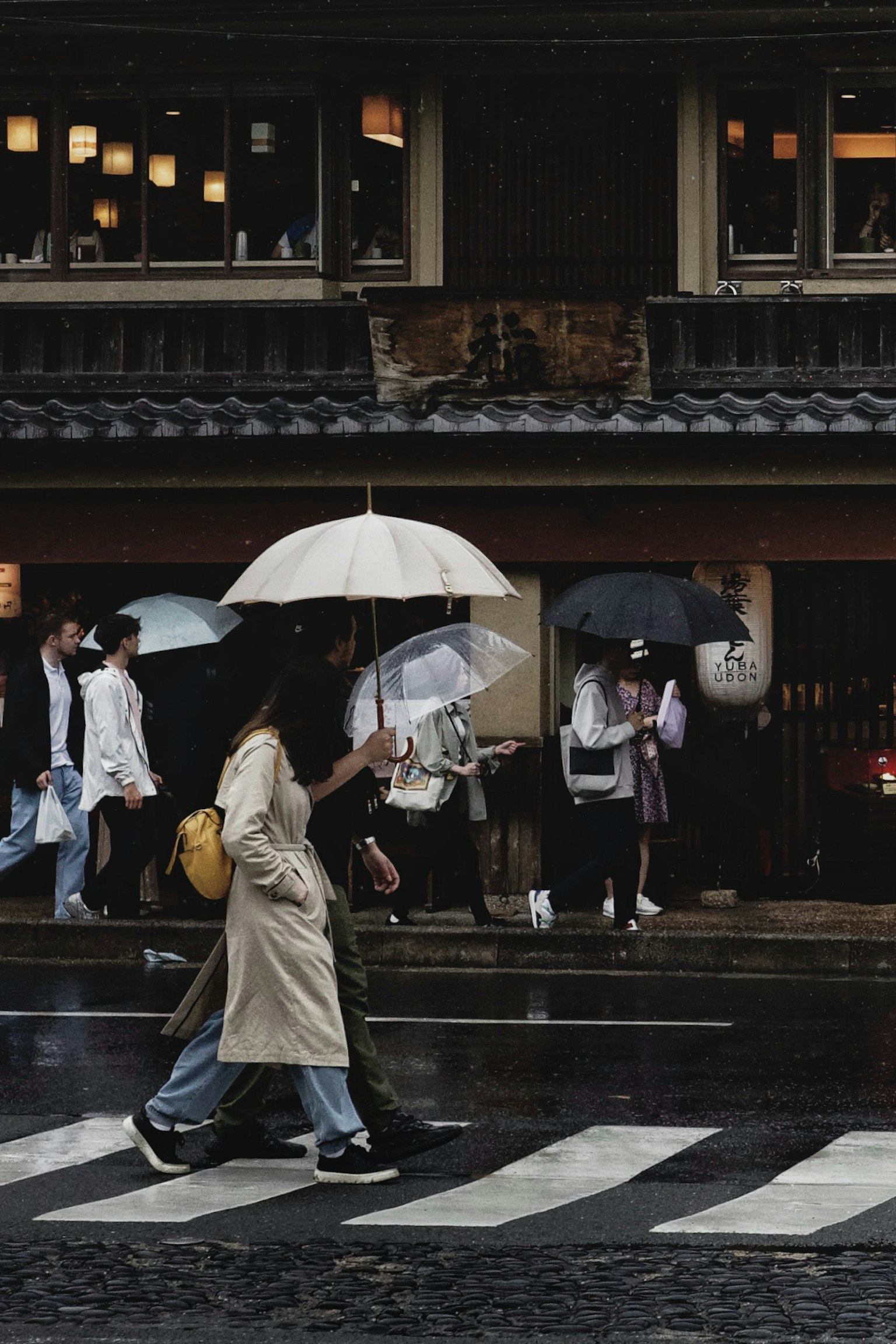 人们在城市环境中雨中撑着伞过马路