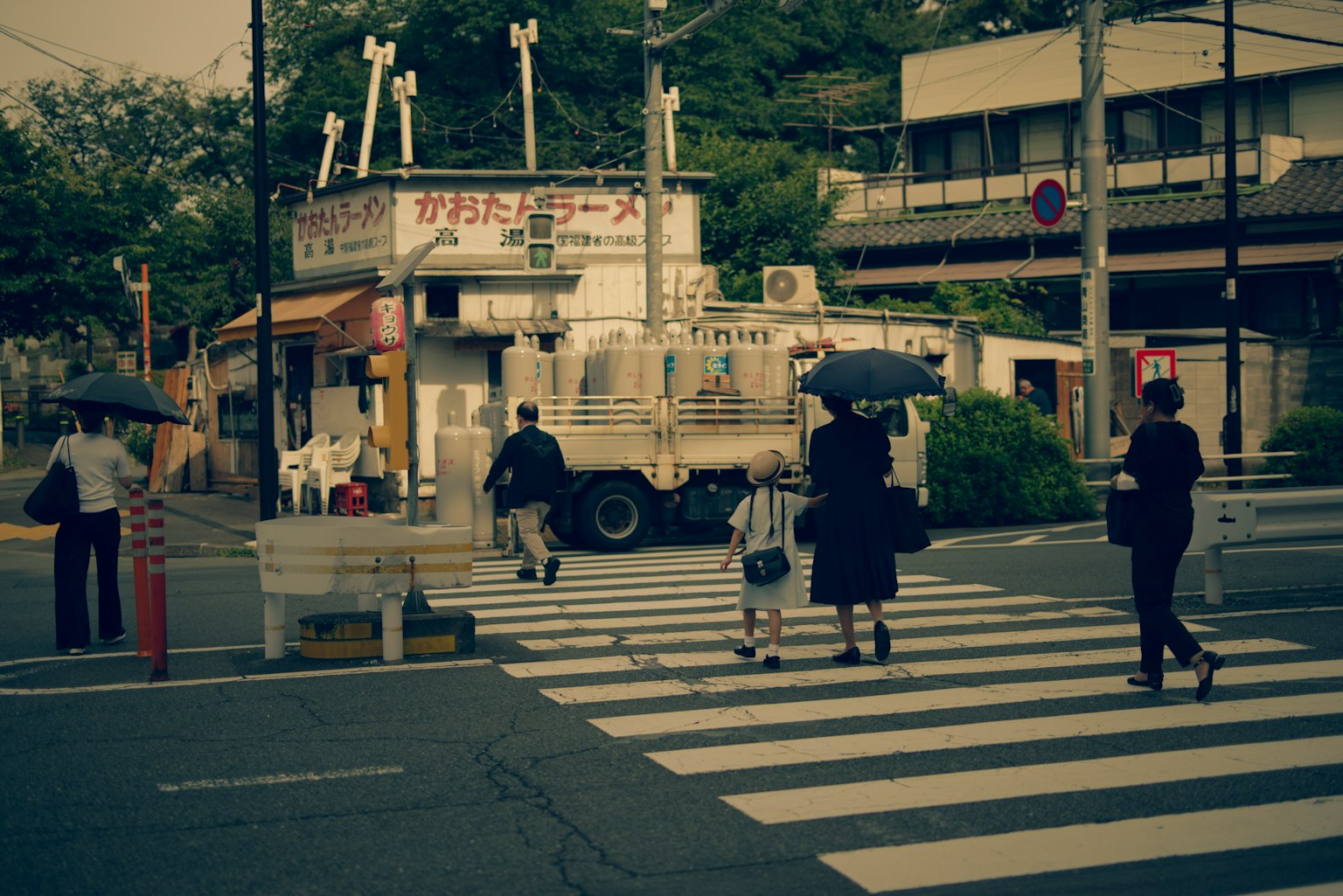 Pedestrians crossing a street with a shop in the background