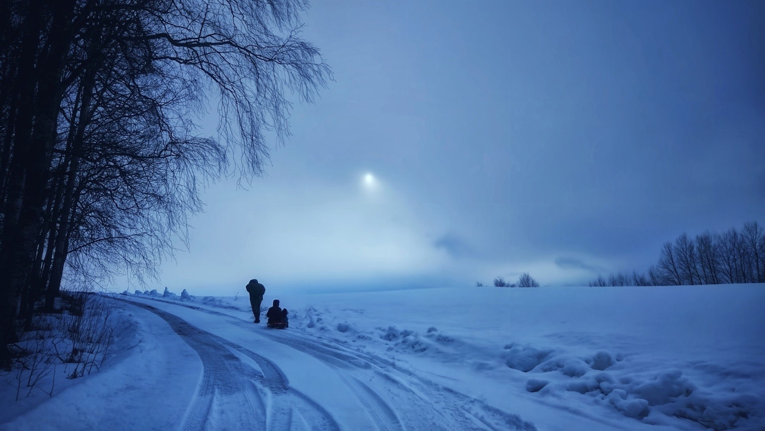 Des personnes marchant sur un chemin enneigé sous un ciel bleu