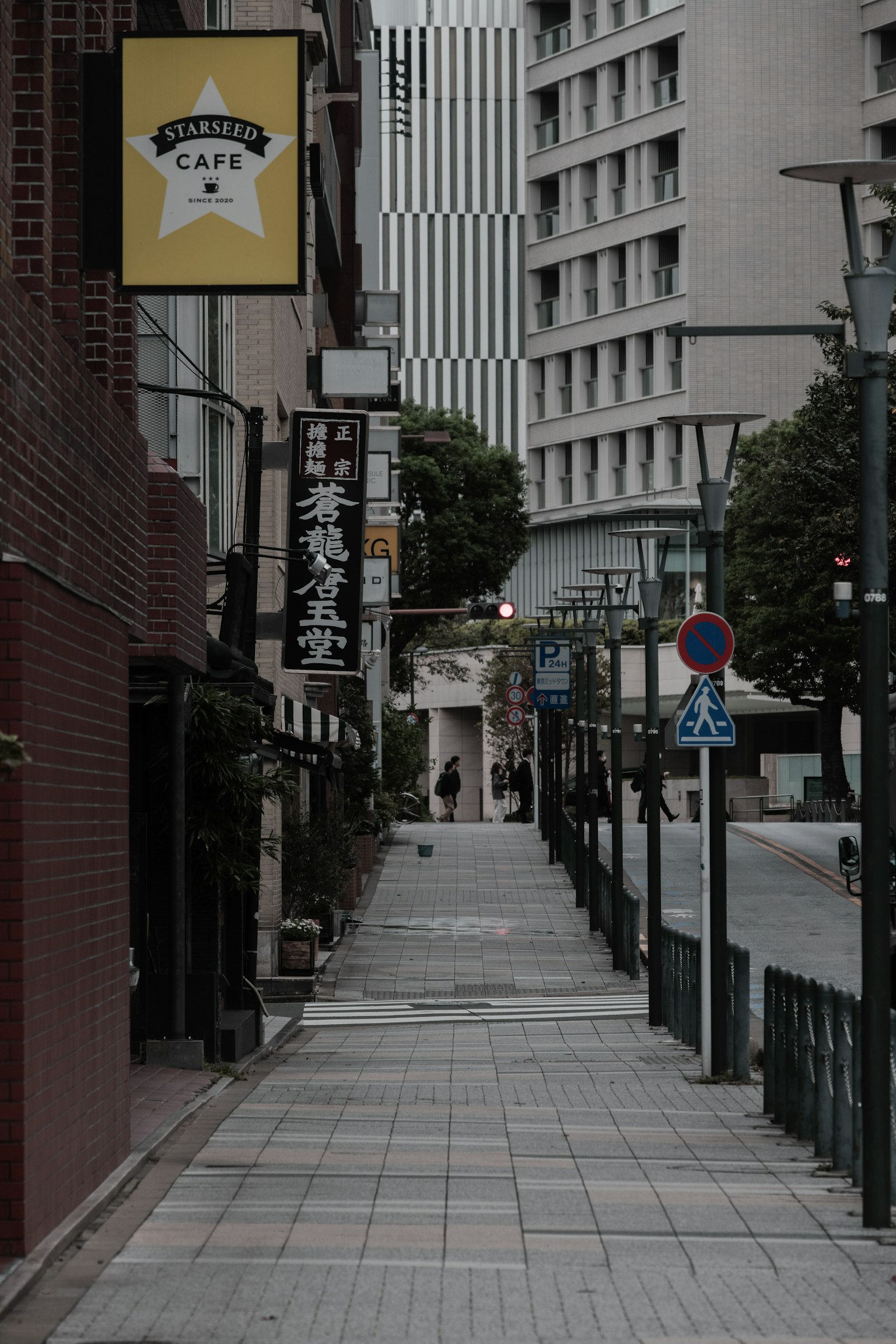 Paved sidewalk along a quiet urban street with commercial signs