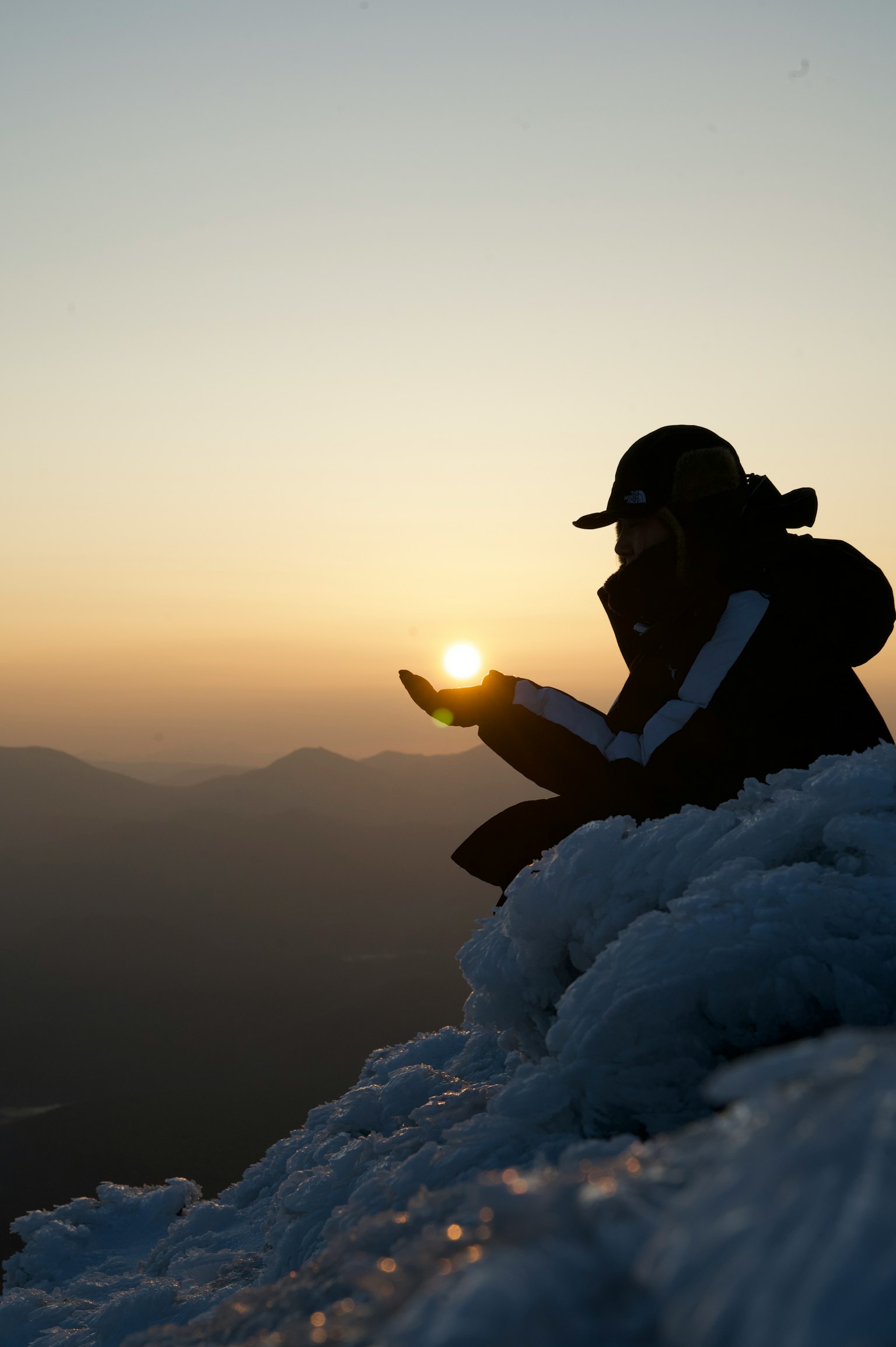 Silhouette of a climber holding the sunset in their hands