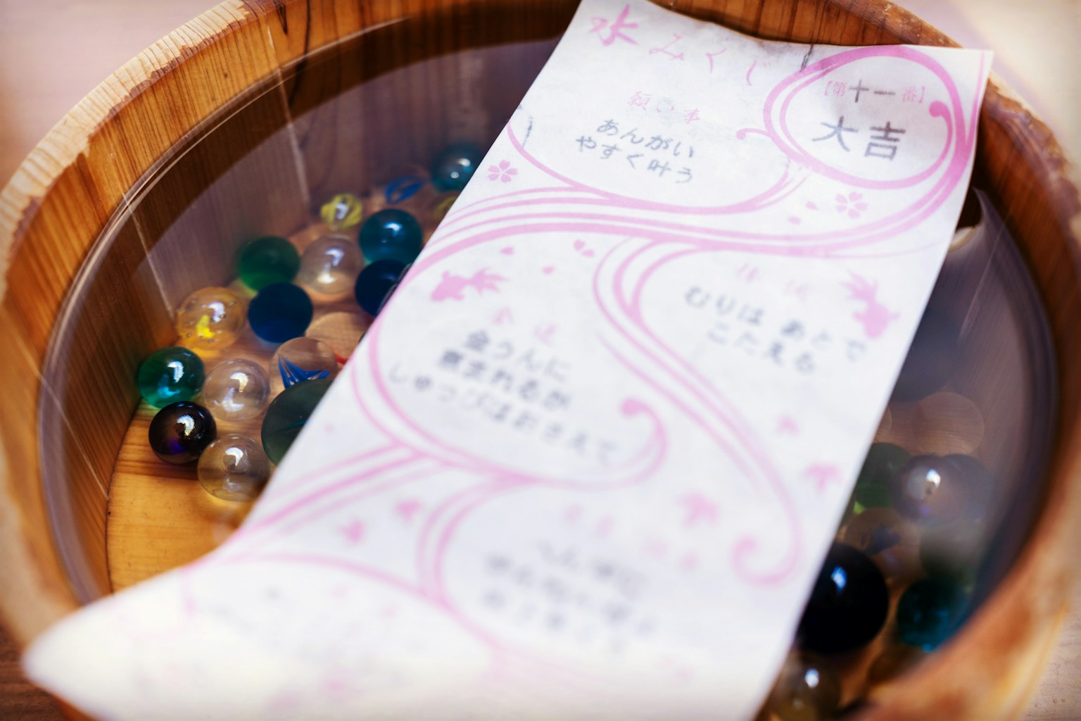木碗中的彩色弹珠和一张日本信息卡