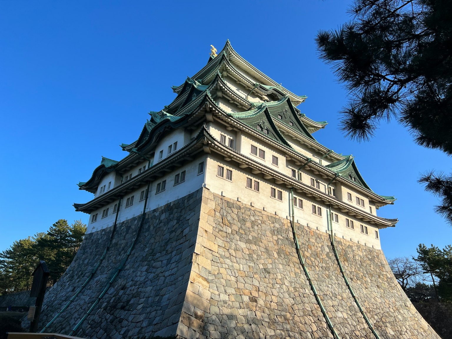 Bild von Nagoya Castle, das seine einzigartige Architektur vor einem klaren blauen Himmel zeigt