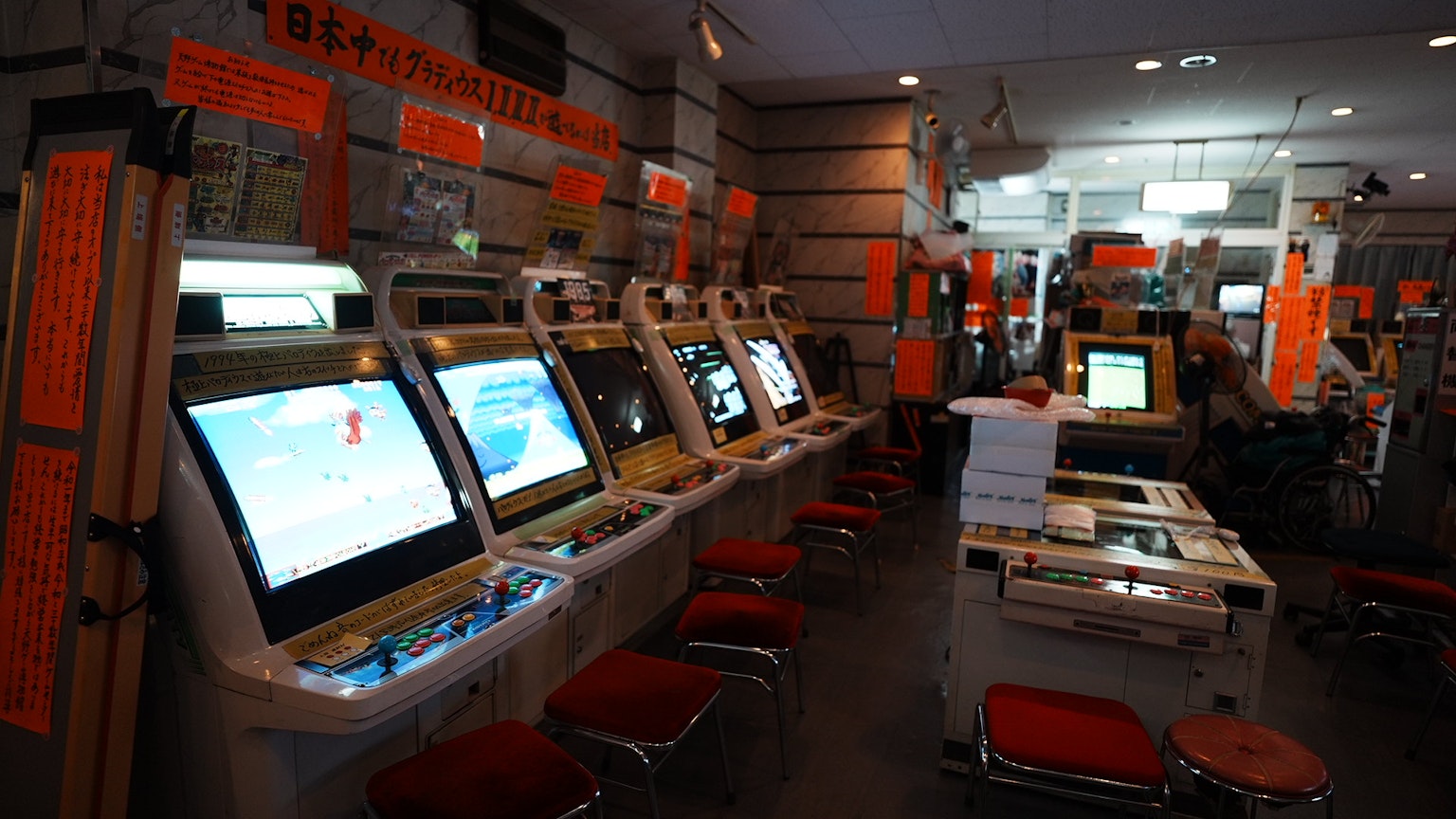 Interior of a game center featuring multiple gaming machines with orange signage