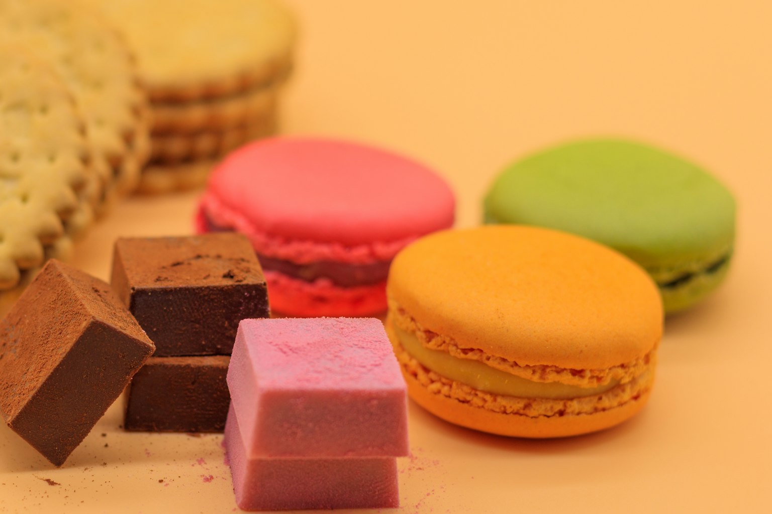 Colorful macarons and chocolate sweets arranged together